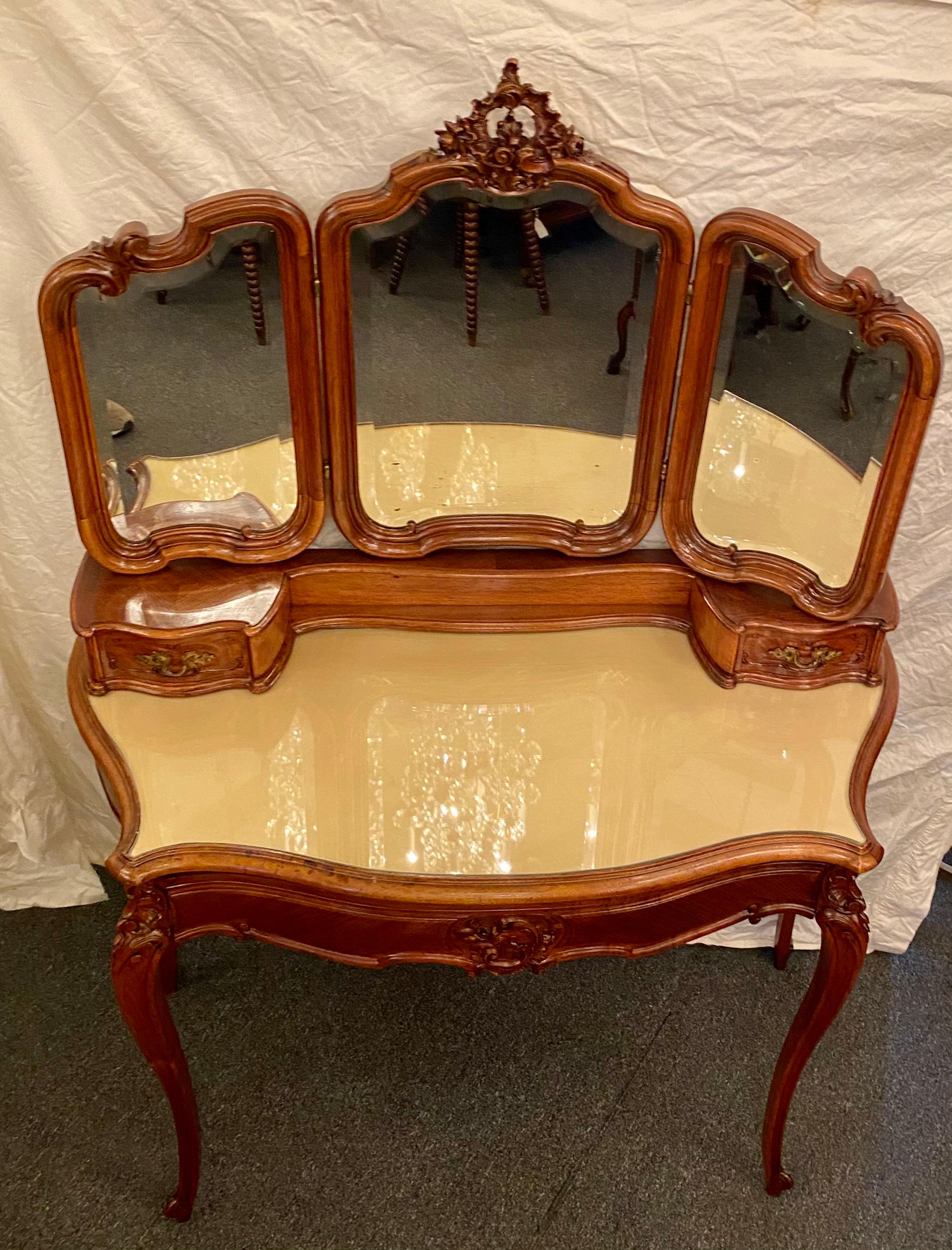 Antique French walnut ladies vanity dressing table with 3-panel beveled mirror, 3 fitted drawers and fitted glass top, circa 1890.

 