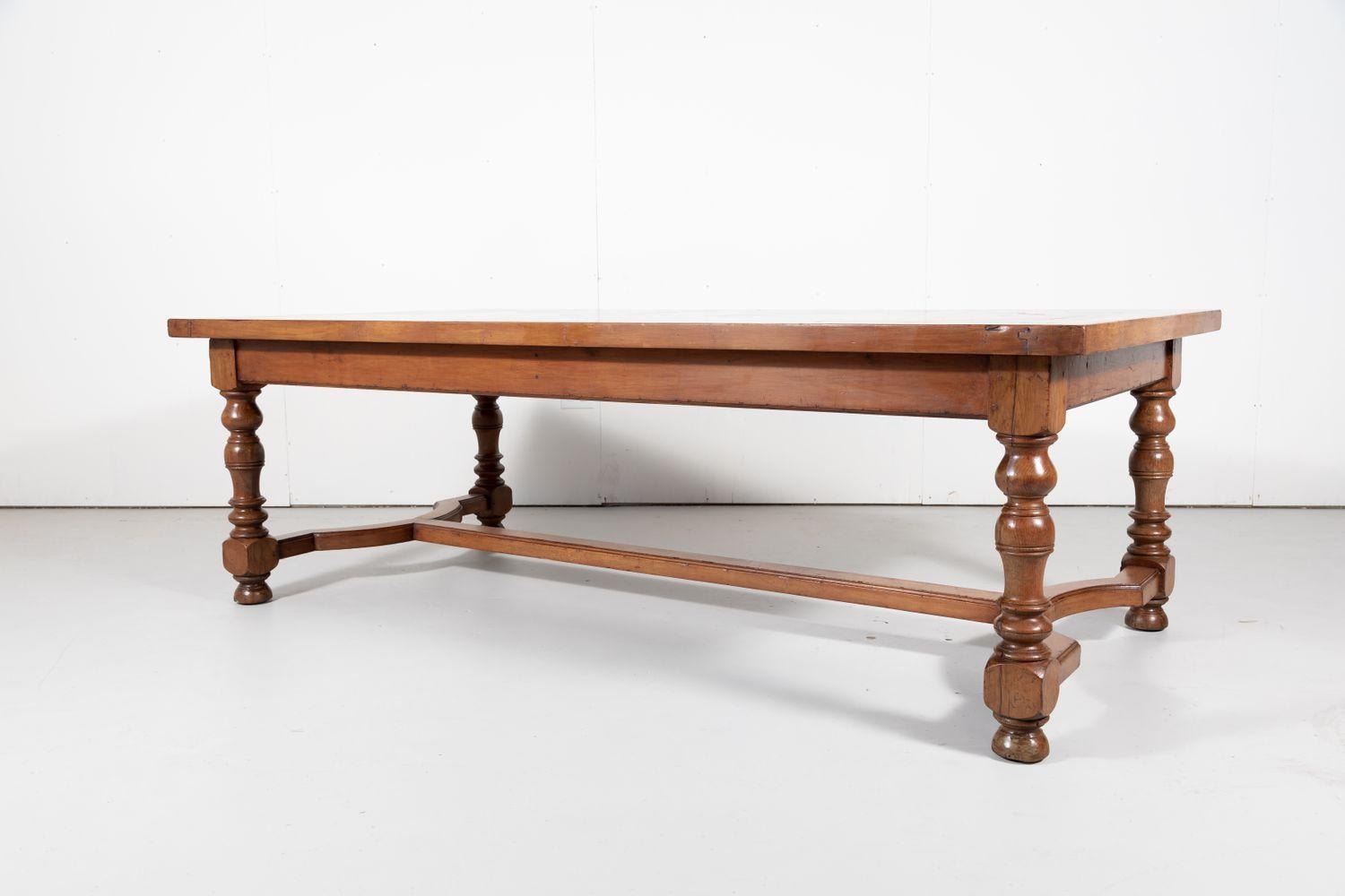 Handsome Louis Philippe style walnut farm table, circa 1890s, from the Normandy region. It has a large rectangular top with parquetry inlay, resting on turned legs joined by a carved and scalloped 