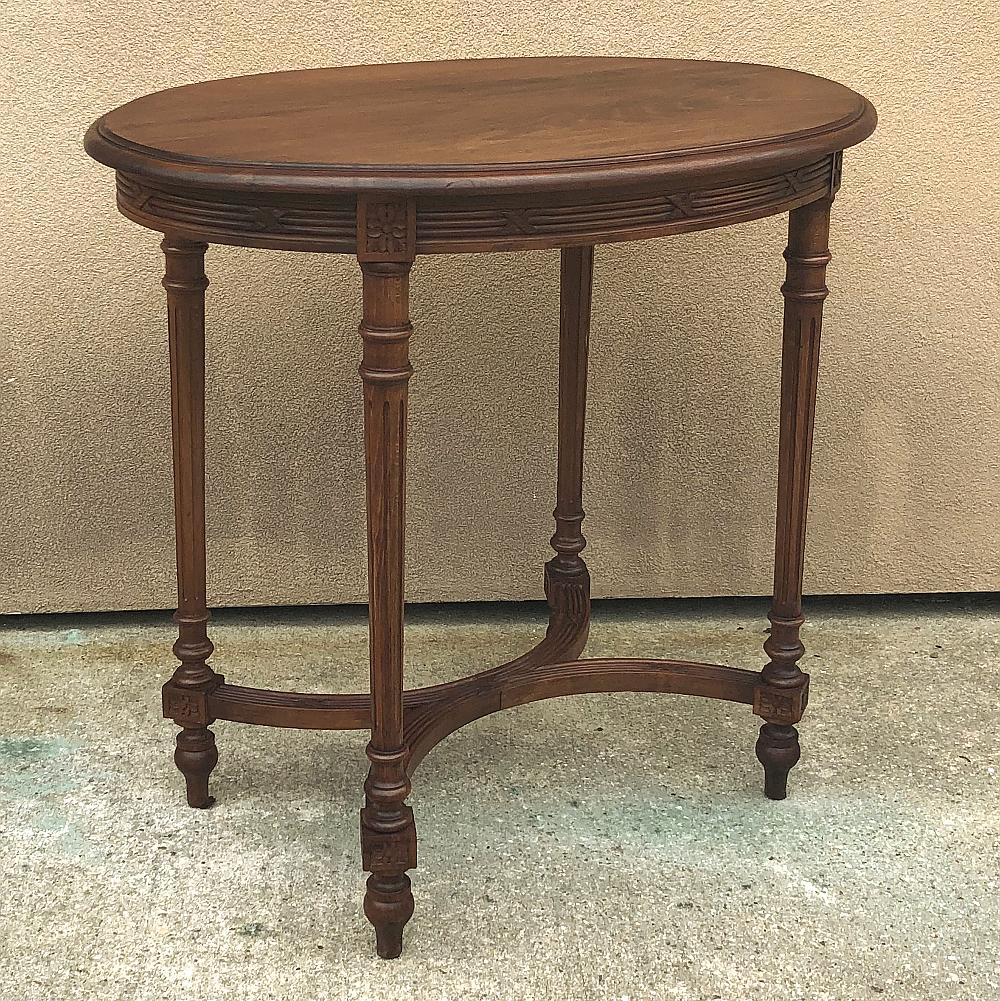 Antique French walnut Louis XVI oval end table represents the essence of the classical style, rendered in luxurious indigenous French walnut for a rich, lustrous effect. The double beveled oval top rests upon an apron carved with banded wheat,