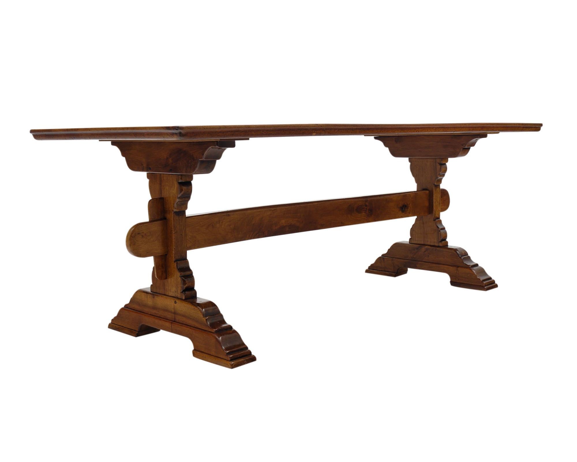 French monastery dining table from an “abbaye” in the Rhone Valley. This piece is made of solid walnut and features an inlayed single plank top and hand carved double pedestals connected with an oblong stretcher.