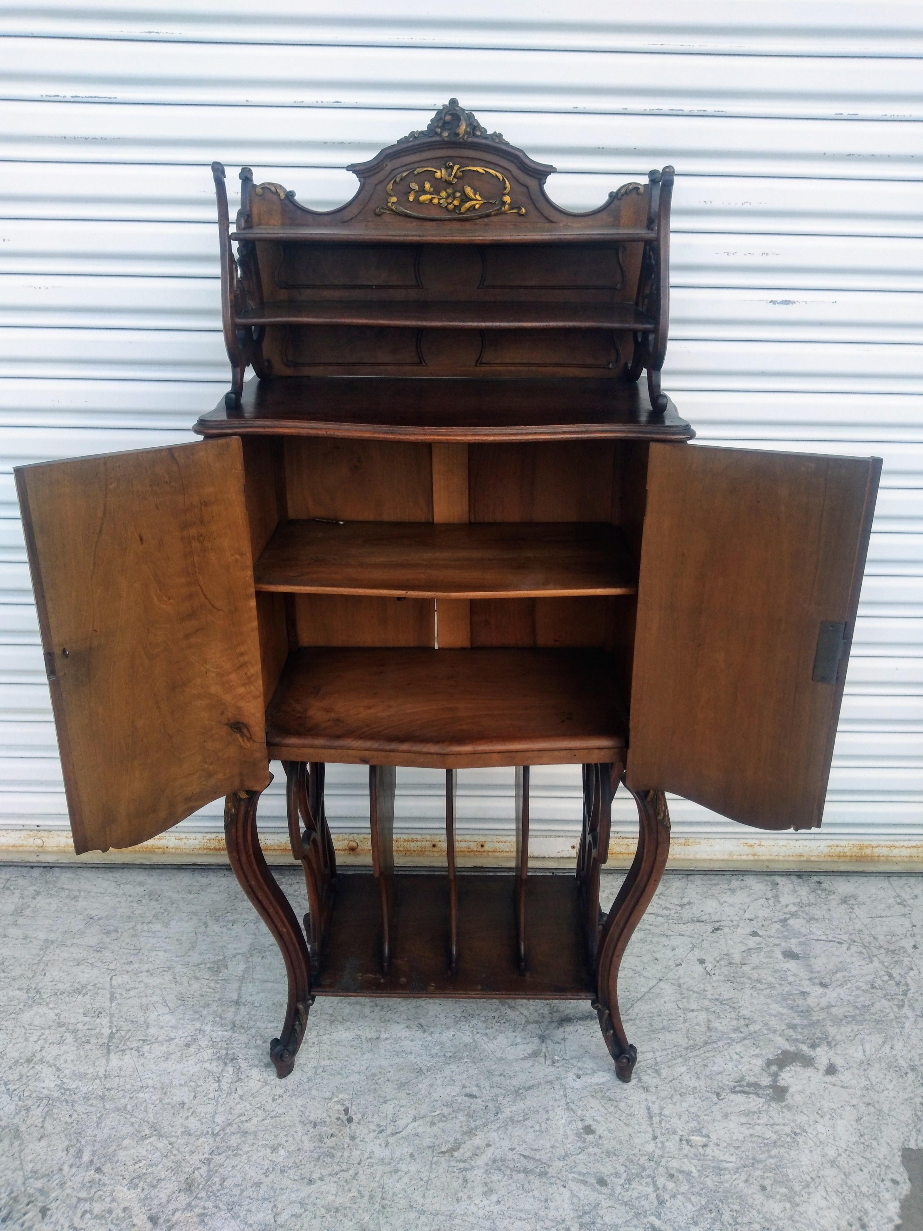 Si tratta di un'opera d'arte straordinaria. Questo mobile musicale è realizzato in legno di noce e presenta splendidi accenti dorati. L'armadio ha un design splendido ed è molto scolpito. La parte superiore è dotata di un ripiano e le ante si aprono