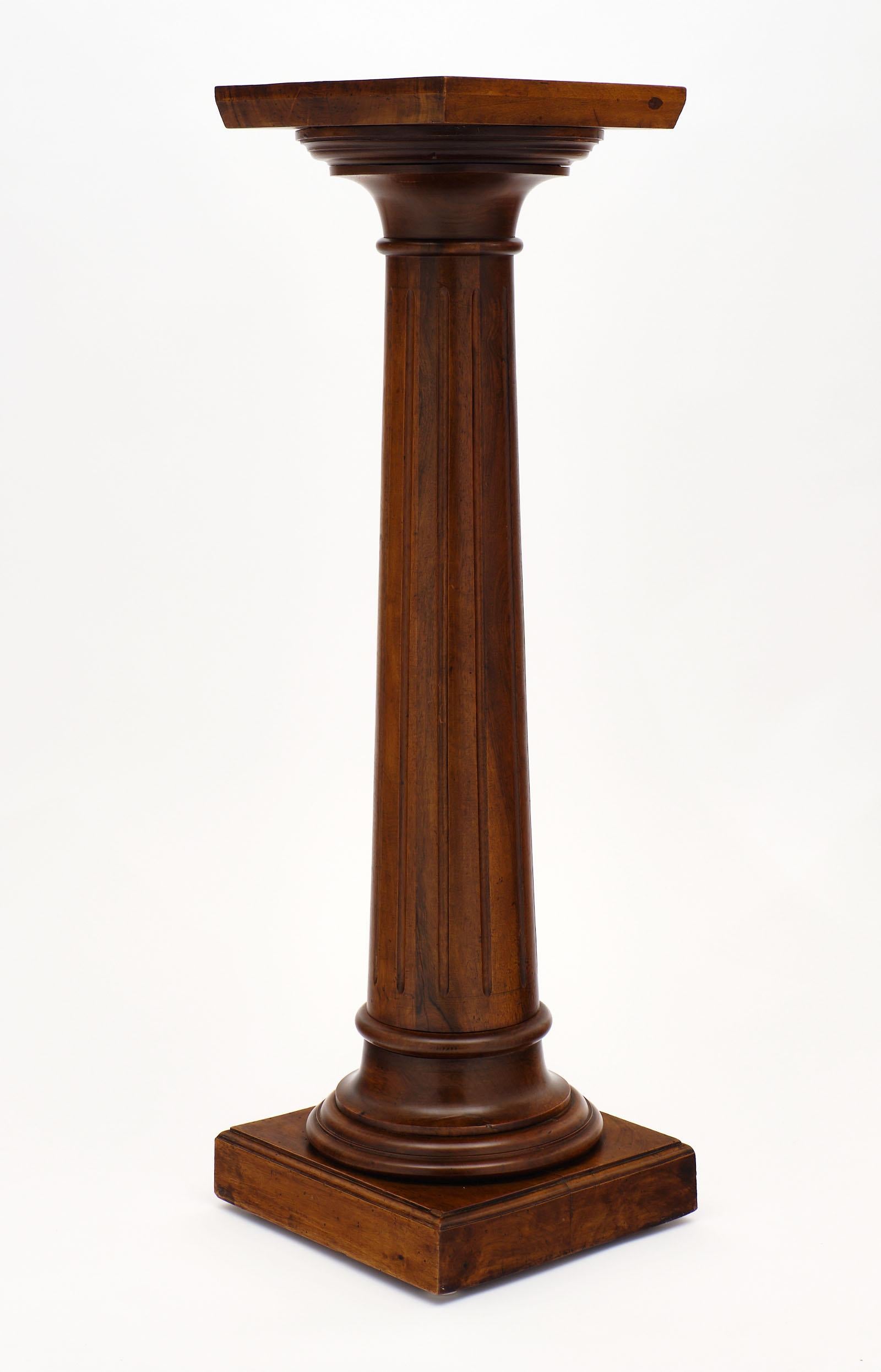 French antique walnut pedestal featuring fluting and a molded base. We love the neoclassic style of this elegant piece!