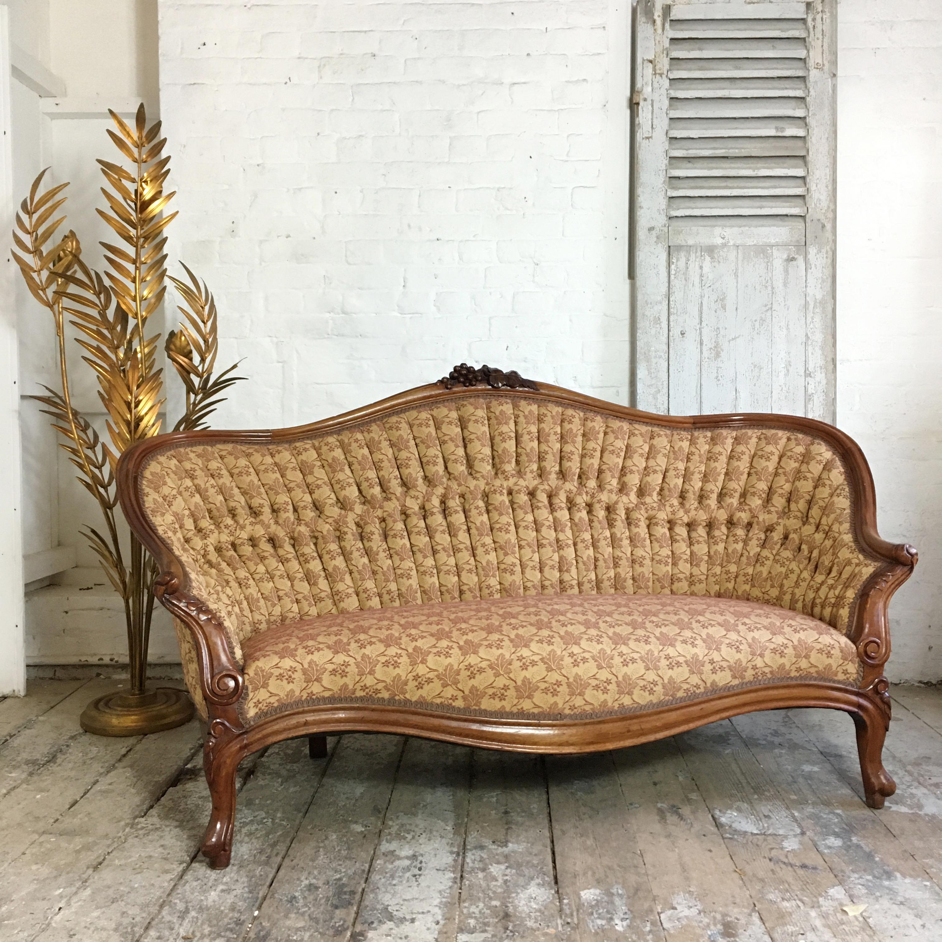Antique French walnut settee, circa 1890s, cabriolet legs, double pleated buttoned back, upholstered in a soft gold beige jacquard with grape design woven through, this Grape design matches back to the carved grape and leaf crest on the top of the