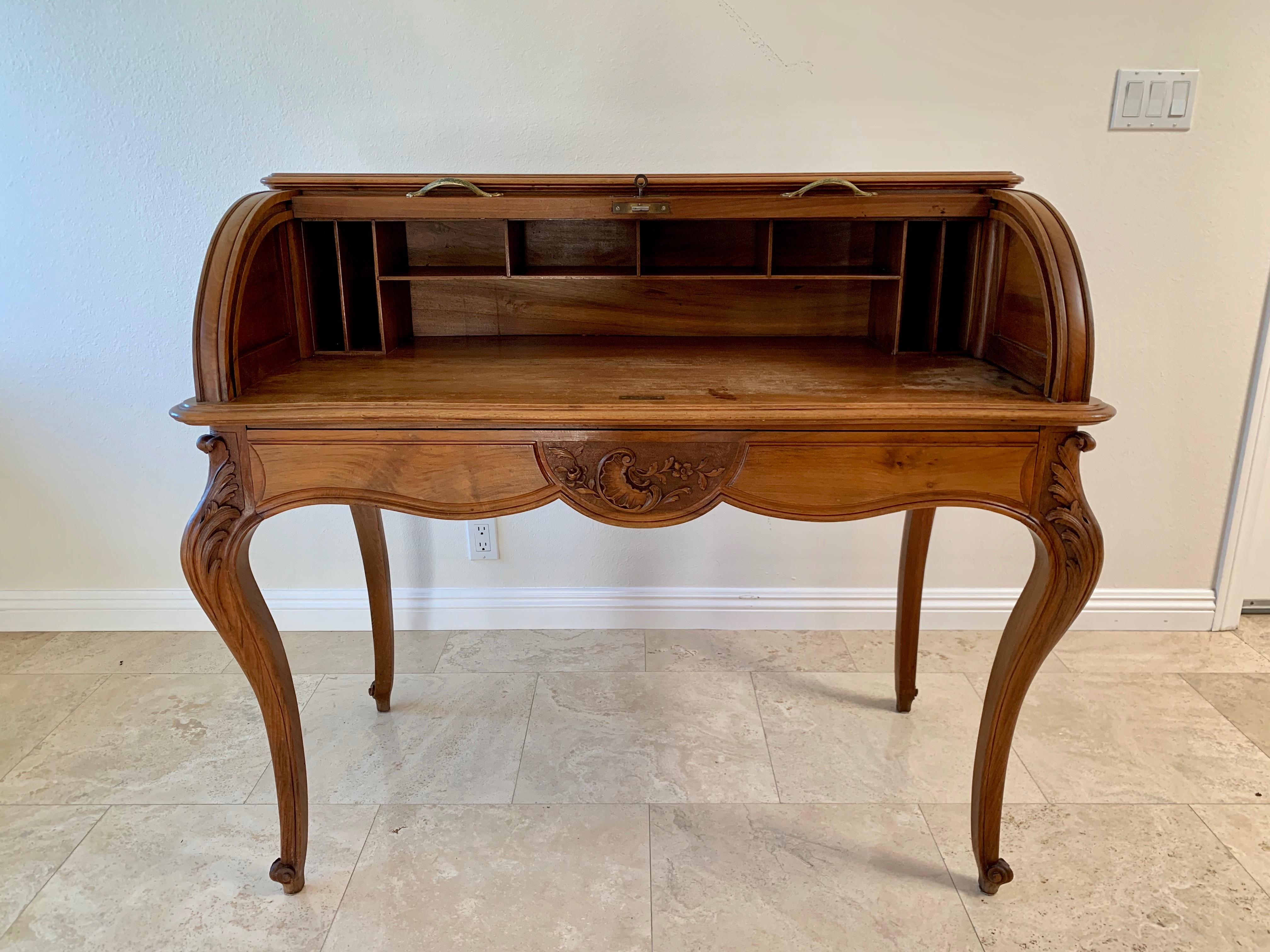 Rare 19th century French walnut roll top desk in the style of Louis XV. The tambour door locks with a key. Also finished on the back so it can be floated in the middle of a room. Desk height is 30.25