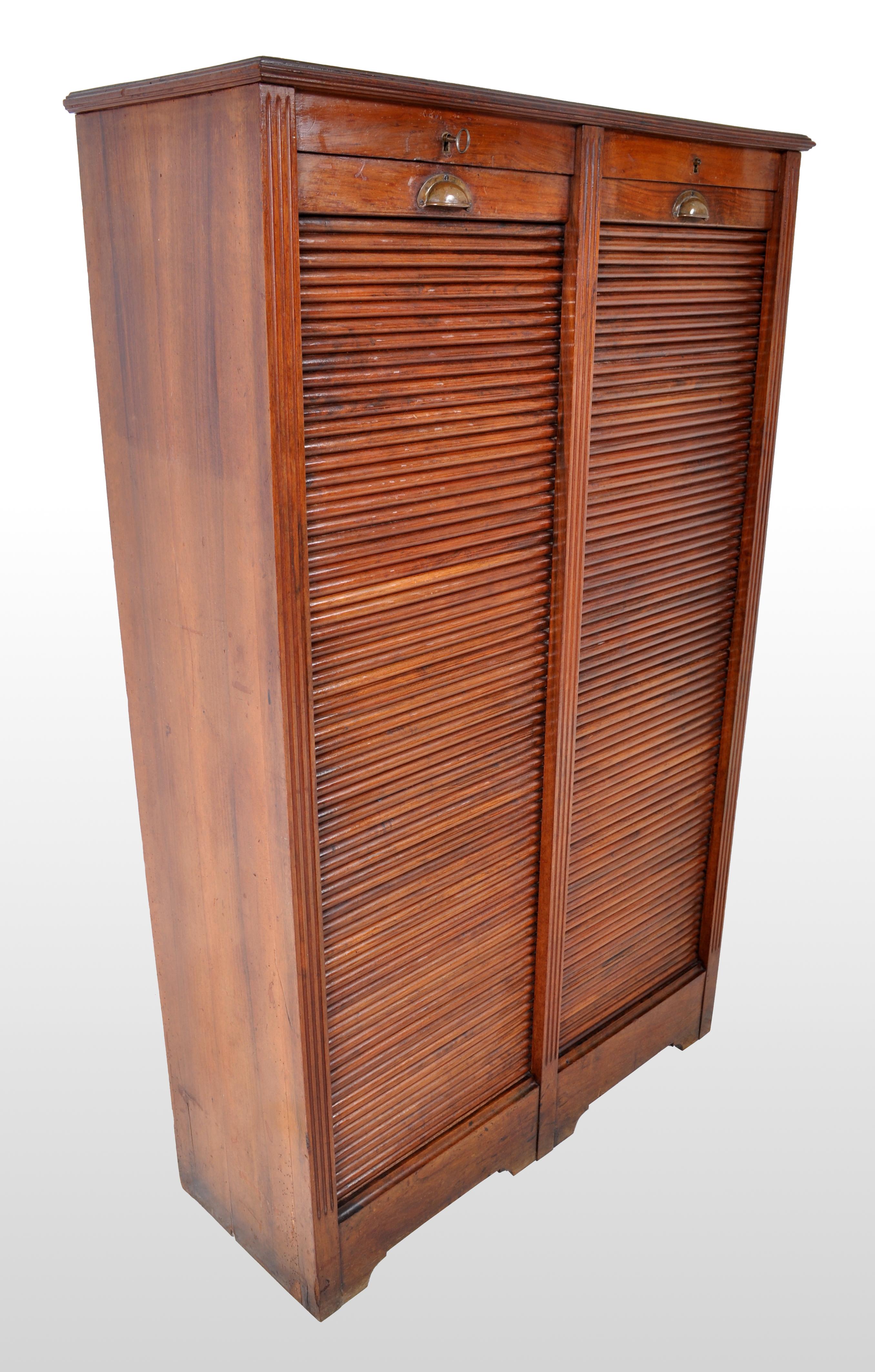 A good antique French walnut twin tambour fronted filing cabinet, circa 1910. The cabinet having twin tambour fronts that roll with ease from the base to the top, each enclosing an equal number of shelves. Both tambours having the original brass