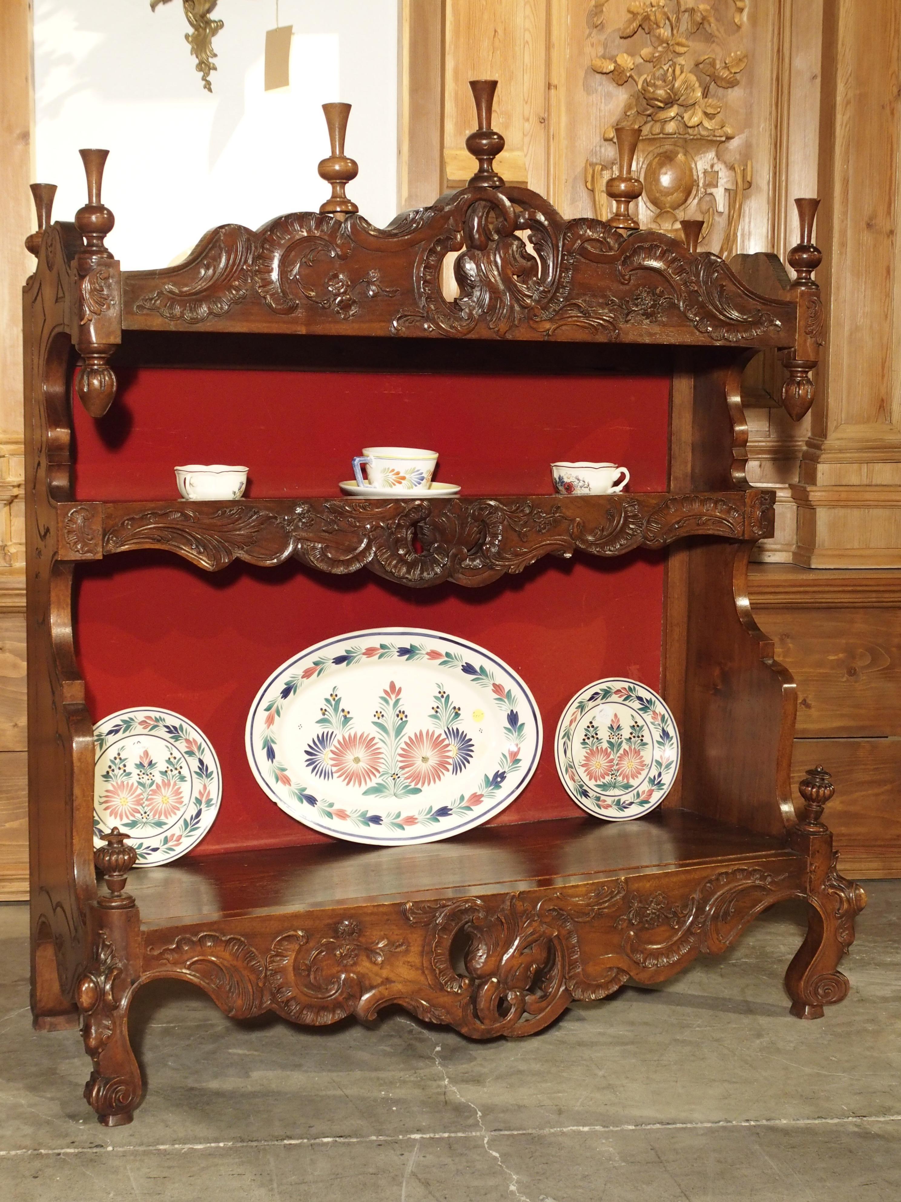 This charming antique French walnut wood estanier or standing plate rack is in the Louis XV style. These would have originally been used to holder pewter dishes and utensils, and the lower, larger shelf would have held pots and faience pieces. Two