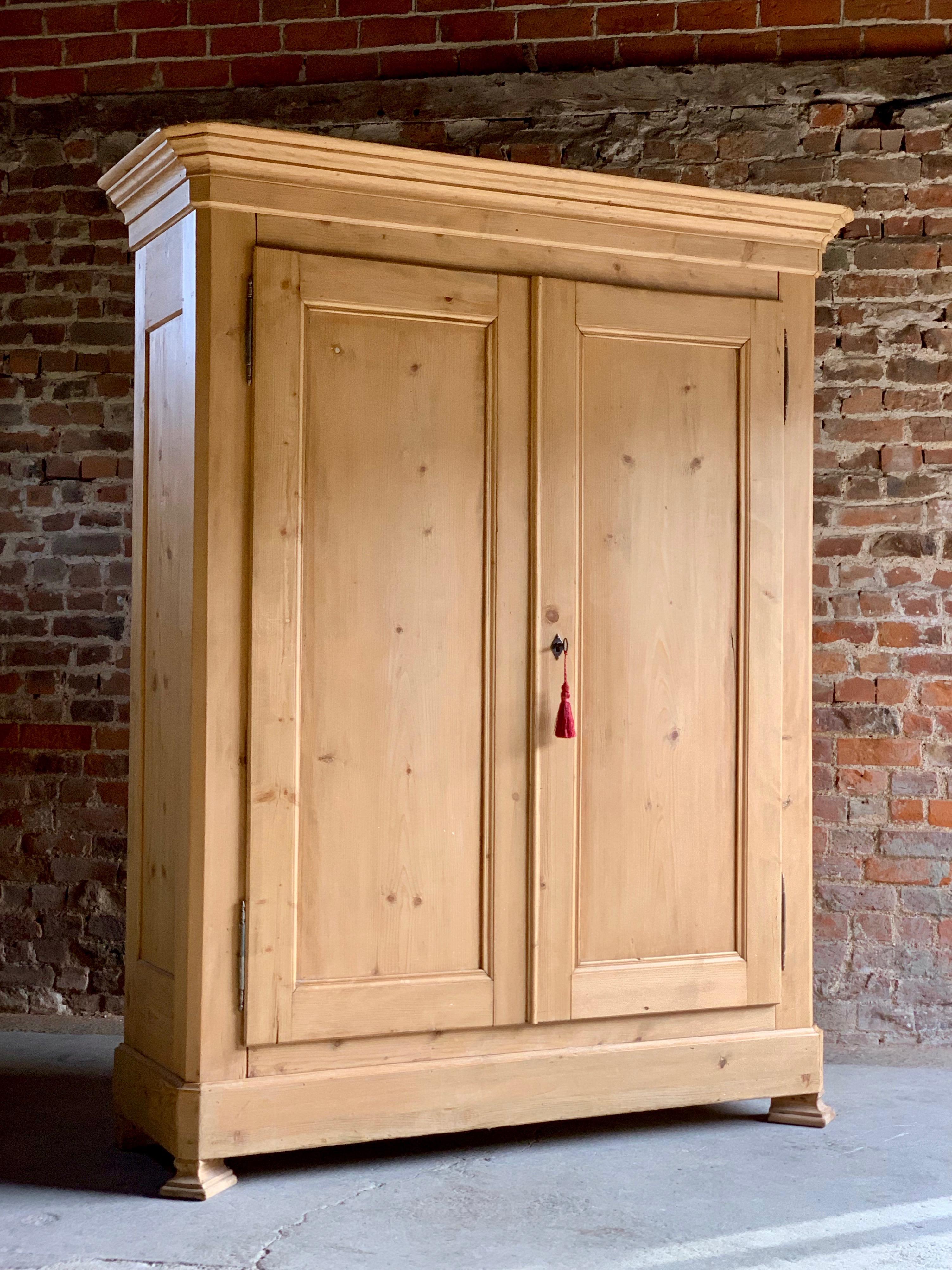 Antique French wardrobe armoire solid pine collapses, circa 1890.

Antique French solid pine armoire wardrobe, circa 1890, the corniced top over two panelled doors enclosing a hanging rail and shelf within raised on a plinth base comes with one