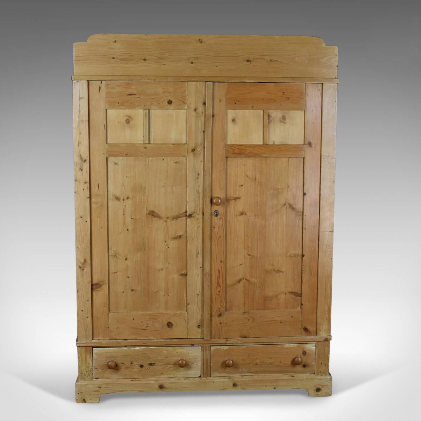 This is an antique French wardrobe, a pine compactum cupboard dating to the early 20th century, circa 1900.

Attractive French Provincial cabinet
Arranged two doors over two drawers
Pine with grain interest in a wax polished finish

Raised on