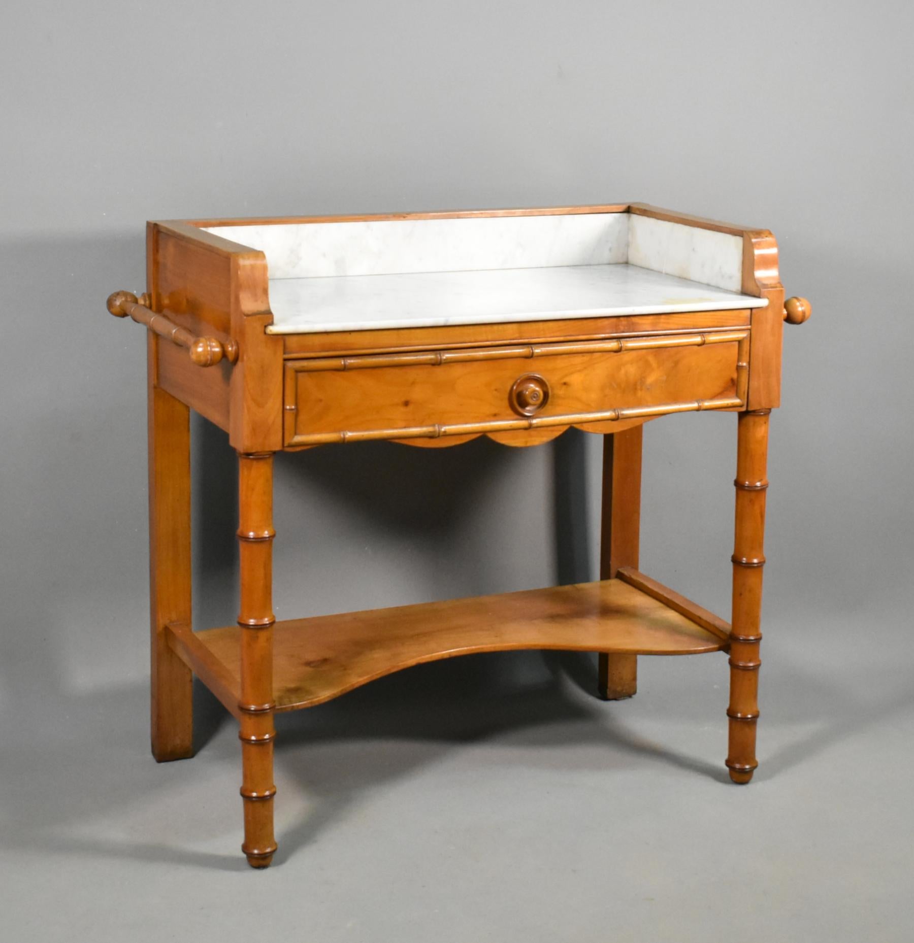 Antique French washstand in Cherry wood and faux bamboo Louis Philippe Style 

This pretty washstand has a lovely light colouration and patina. 

It features a white and grey variegated marble top and surround with matching turned towel rails to