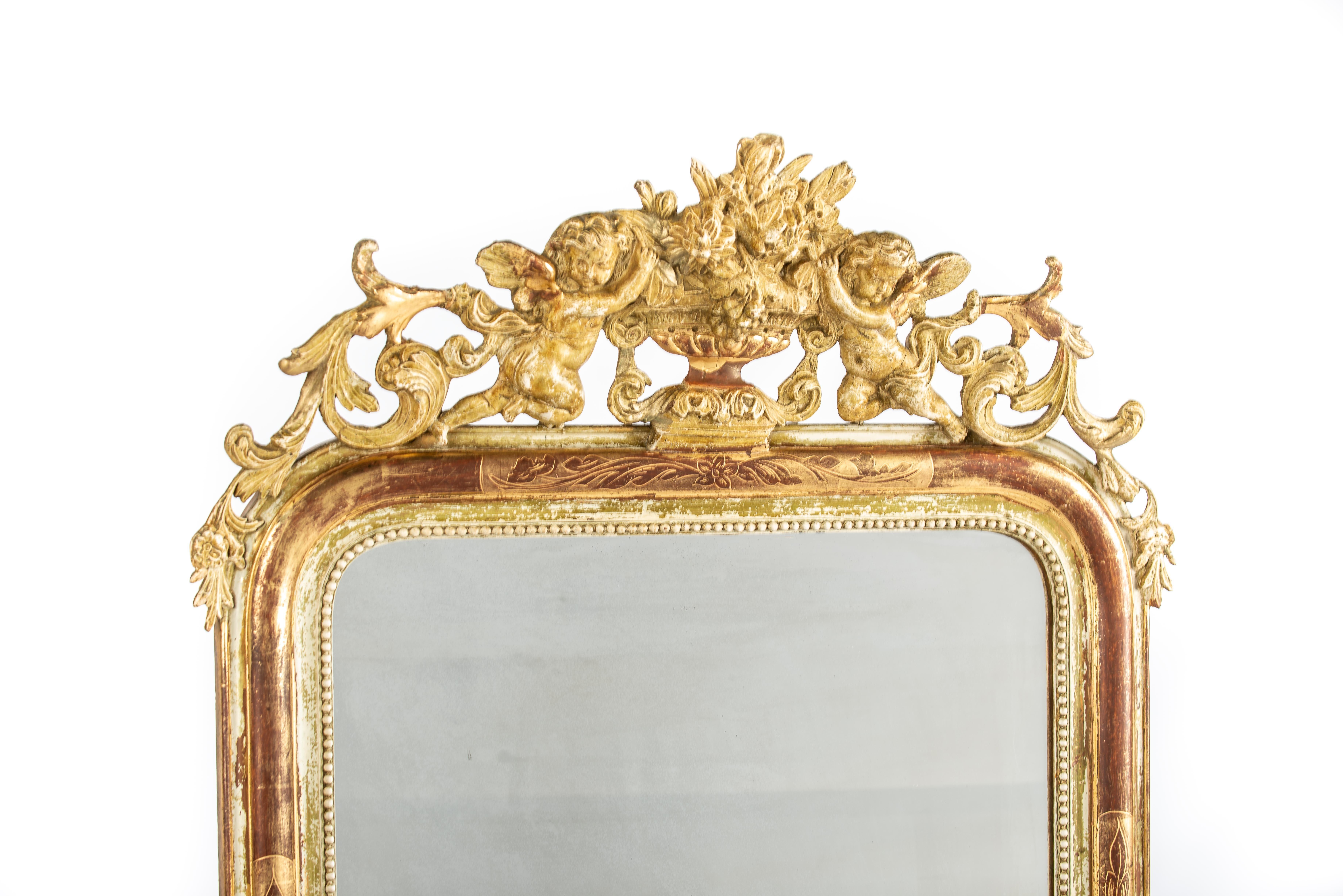 Offered here is a beautiful antique French Louis Philippe mirror originating from the Alsace region and crafted around 1870. The mirror features the distinctive rounded top corners typical of the Louis Philippe style. At the top, it is adorned with