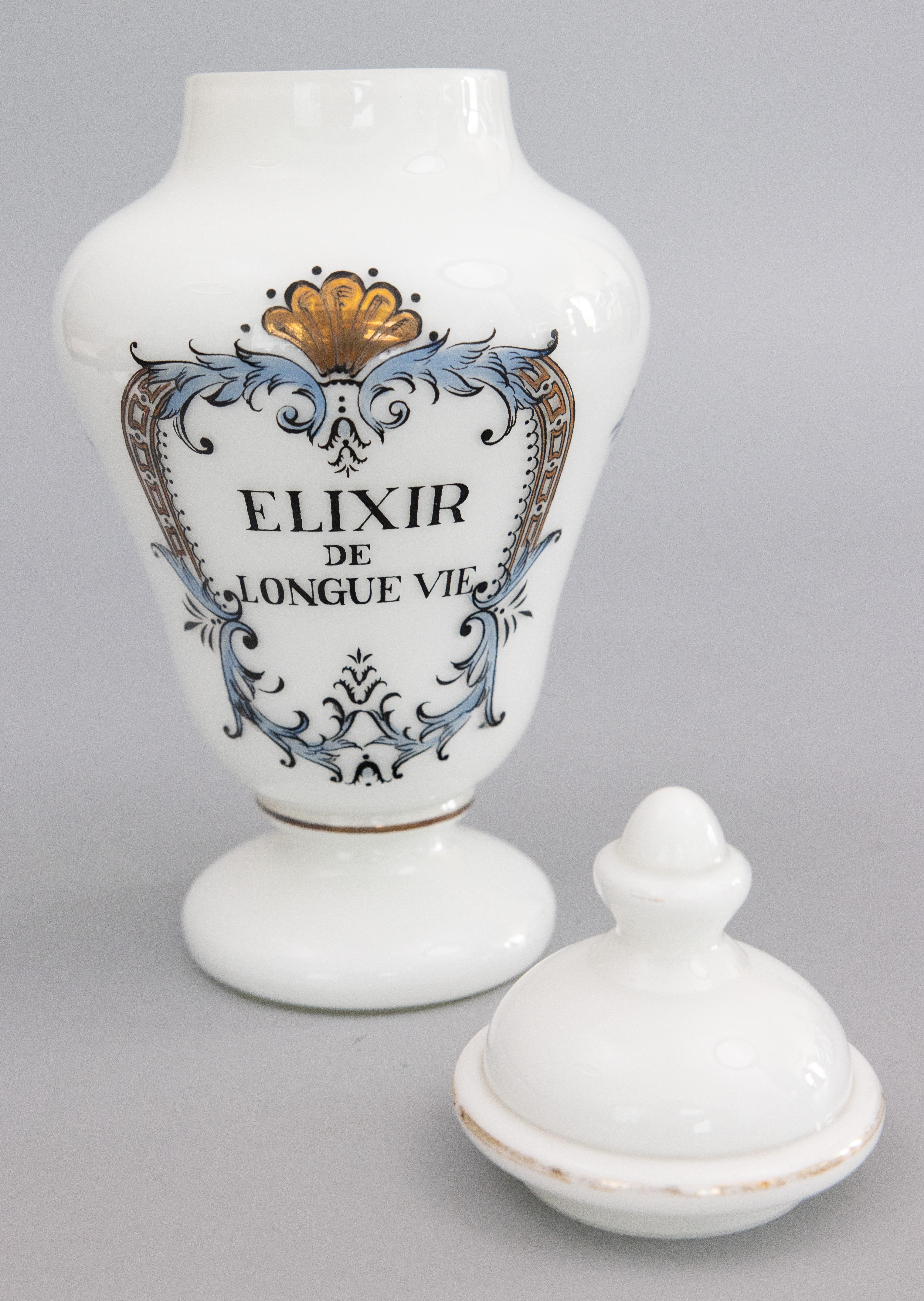 A beautiful antique early 20th-Century French glass lidded apothecary or pharmacy jar. It is decorated with lovely light blue scrolls and gold accents surrounding the words 