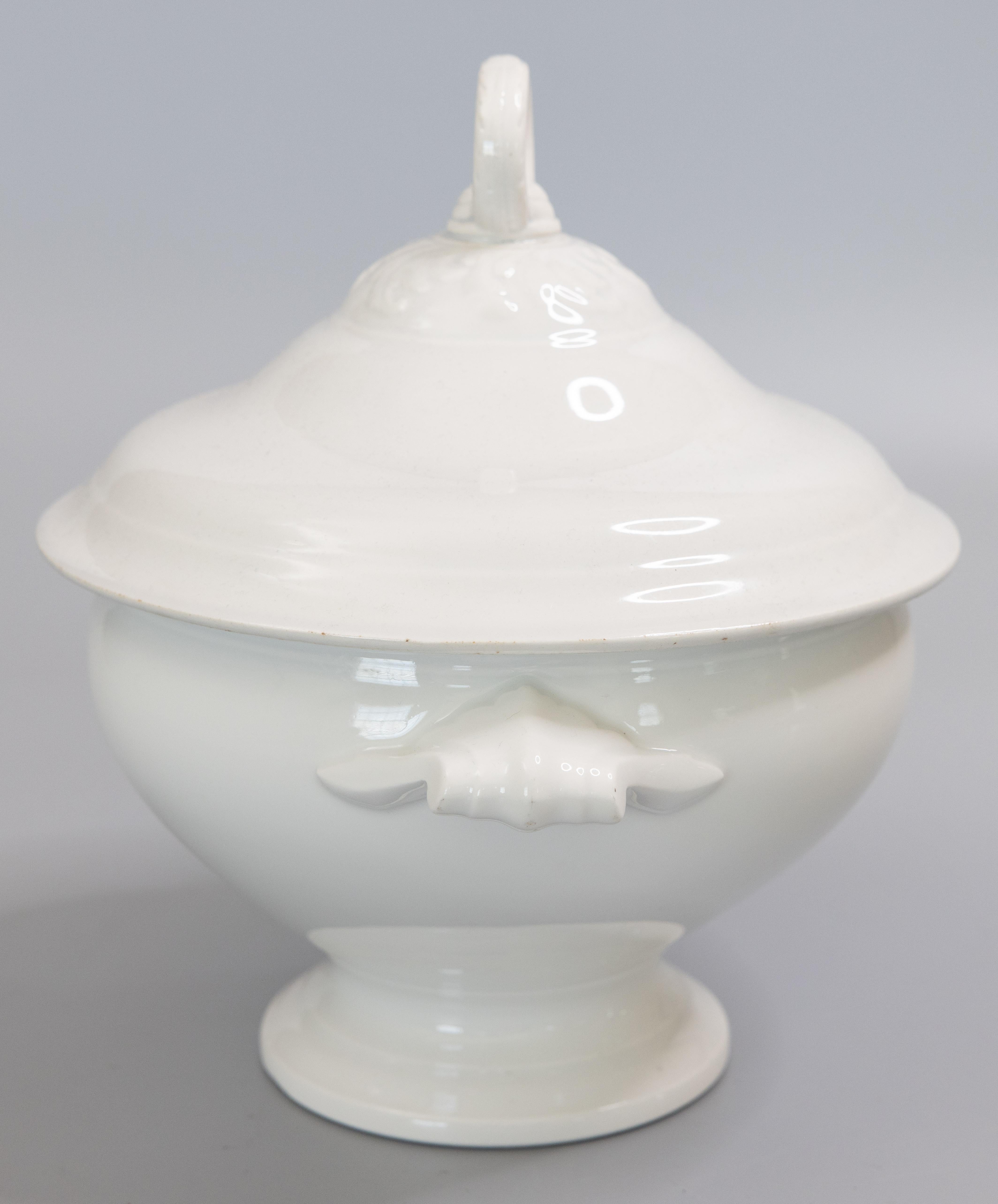 A gorgeous antique early 20th-Century French white ironstone lidded soup tureen. No maker's mark. This fine soup tureen is a nice large size and has a decorative finial and lovely ornate handles. It's perfect for display or serving at your next