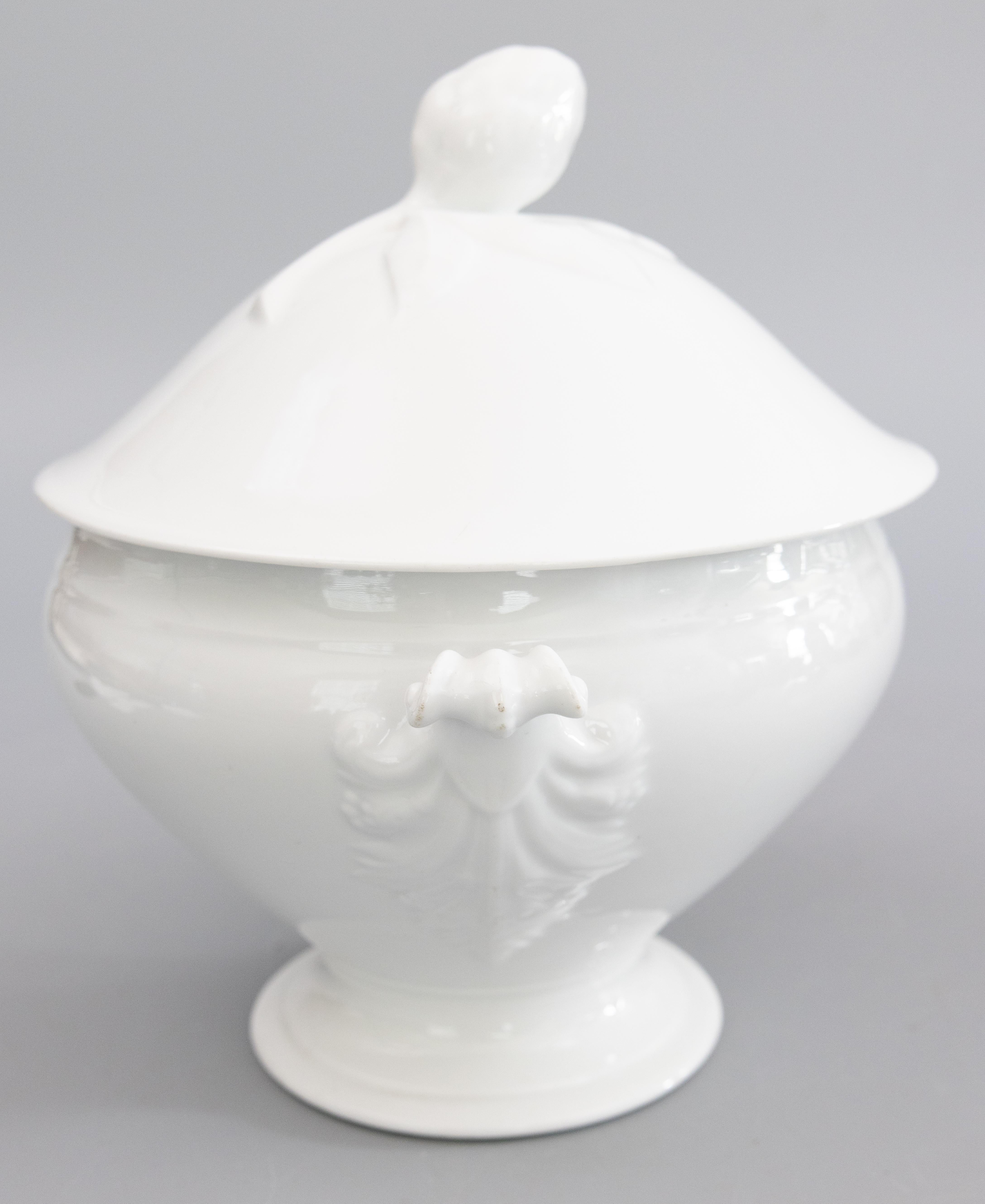 A gorgeous antique French white ironstone lidded soup tureen, circa 1900. No maker's mark. This fine soup tureen has a decorative finial and lovely ornate handles. It's perfect for display or serving at your next party. 

DIMENSIONS
10.75ʺW × 9ʺD ×