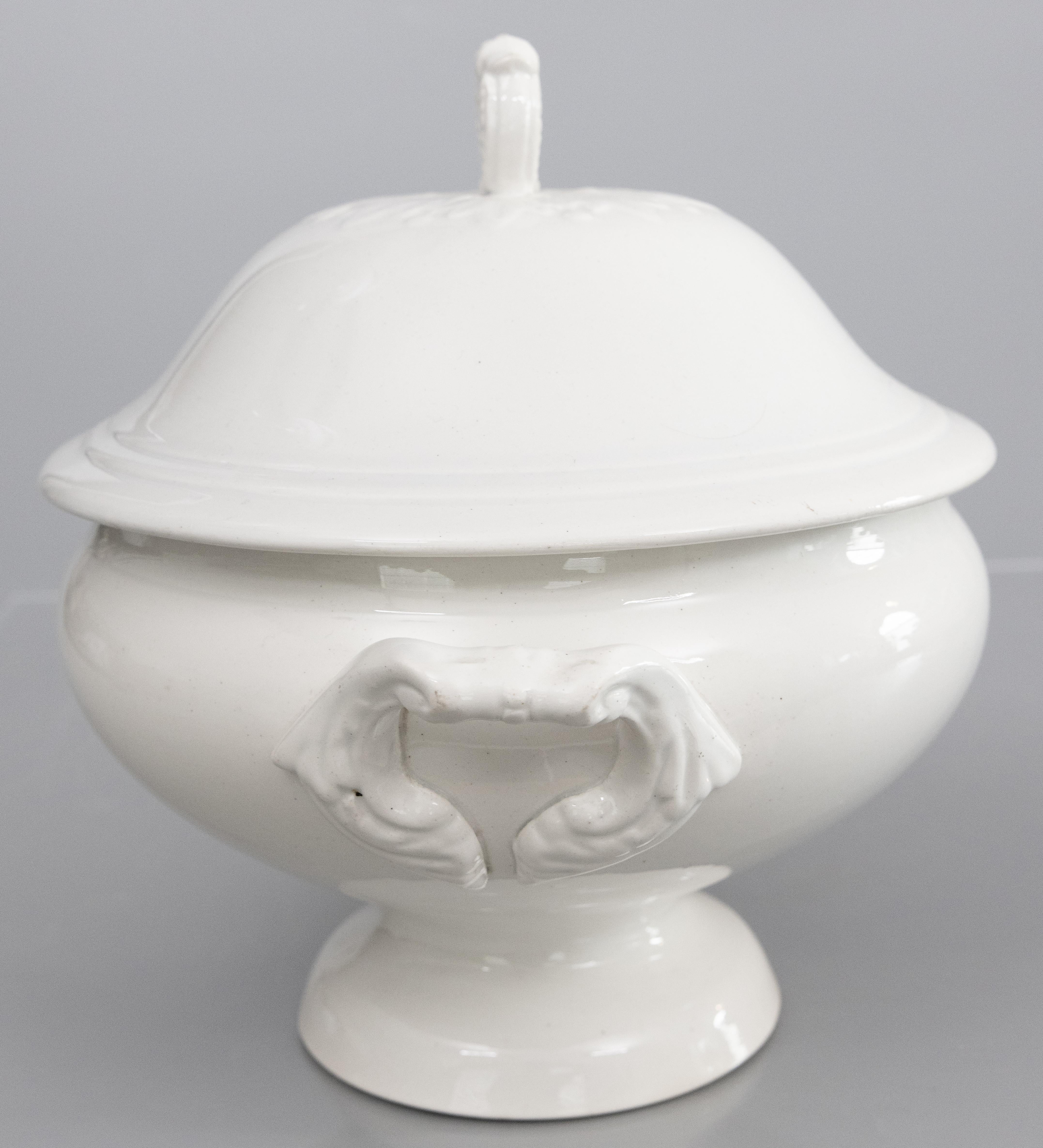 A gorgeous antique French white ironstone lidded soup tureen, circa 1900. No maker's mark. This fine soup tureen has a decorative finial and lovely ornate handles. It displays beautifully and would be wonderful added to an ironstone collection or