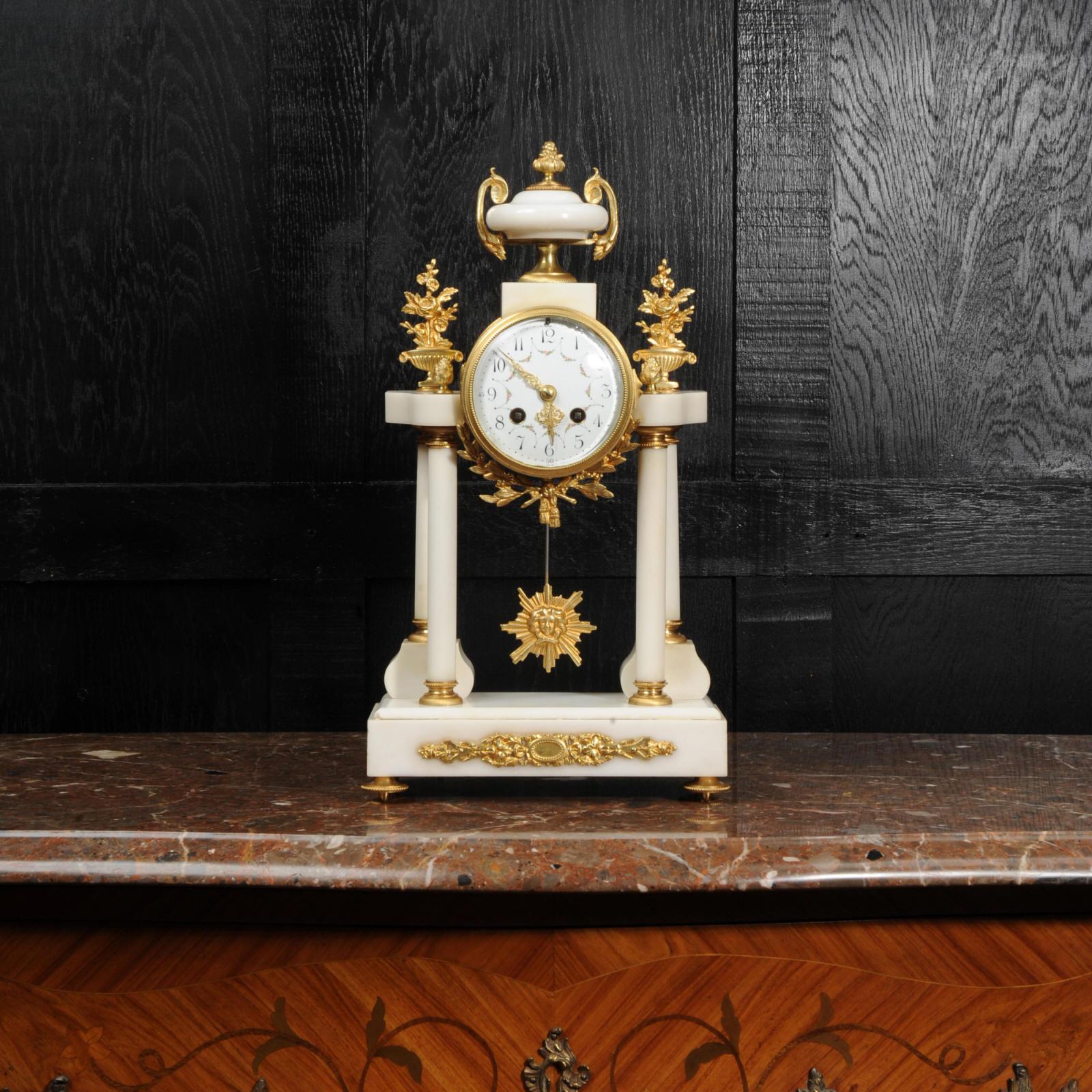 A beautiful original antique French portico clock, circa 1880. It is made of white marble mounted with ormolu (finely gilded bronze). The movement is held aloft on four marble pillars with the ormolu pendulum swinging gently below.

The dial is