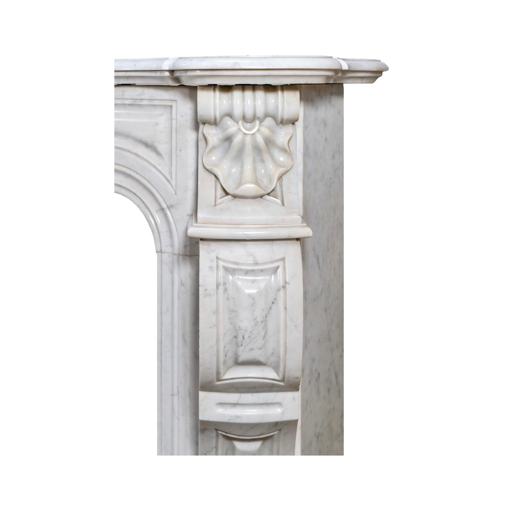 Una antigua repisa recuperada de estilo Luis XVI, meticulosamente elaborada con mármol de Carrara veteado en blanco, procedente de la Francia del siglo XVIII. Esta impresionante pieza presenta motivos de volutas talladas a mano en forma de concha