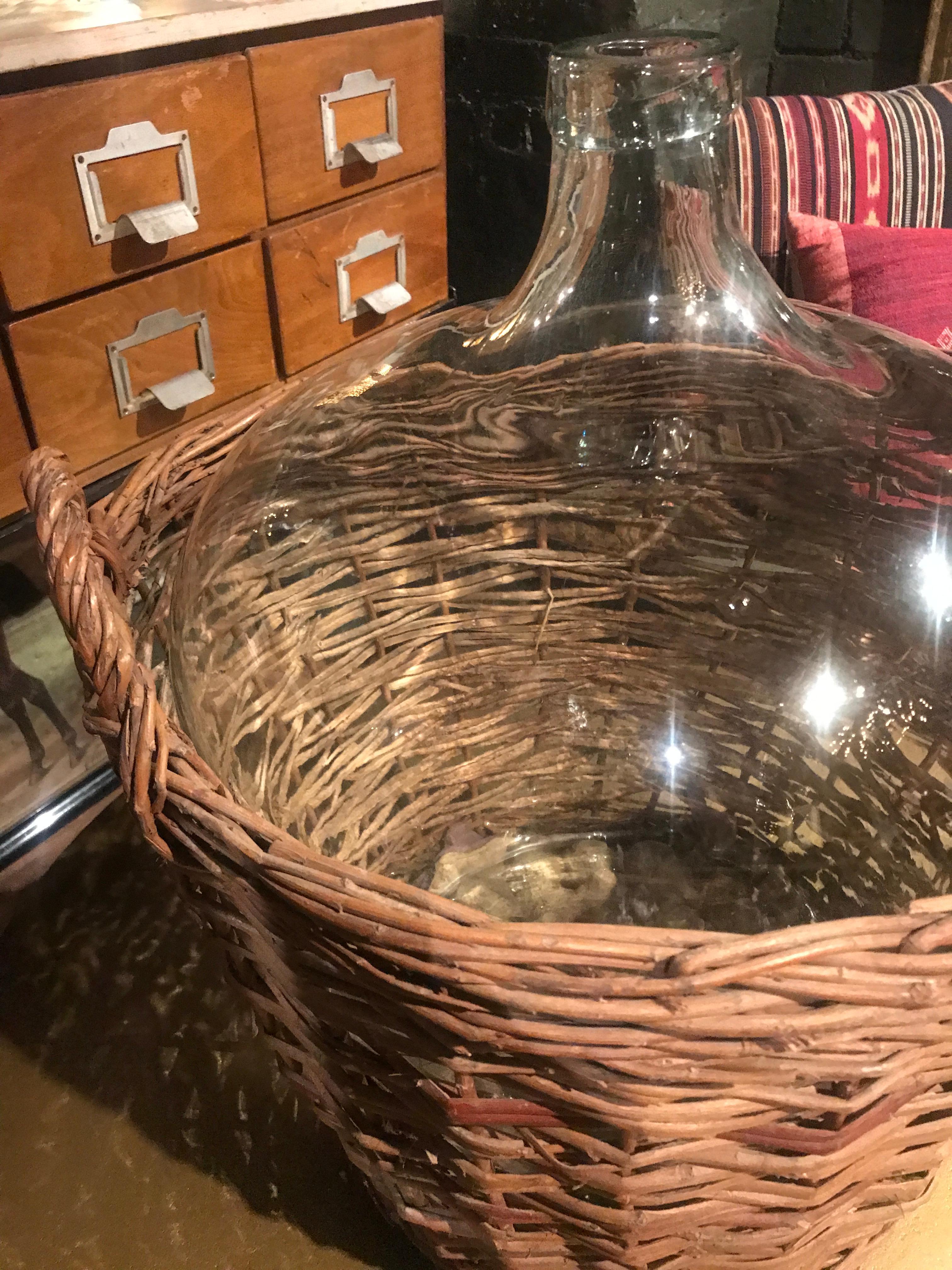 A wonderfully large antique French demijohn jug with its original wicker encasing. Demijohn originally referred to any glass vessel with a large body and small neck, enclosed in wickerwork. The word presumably comes from the French dame-jeanne,