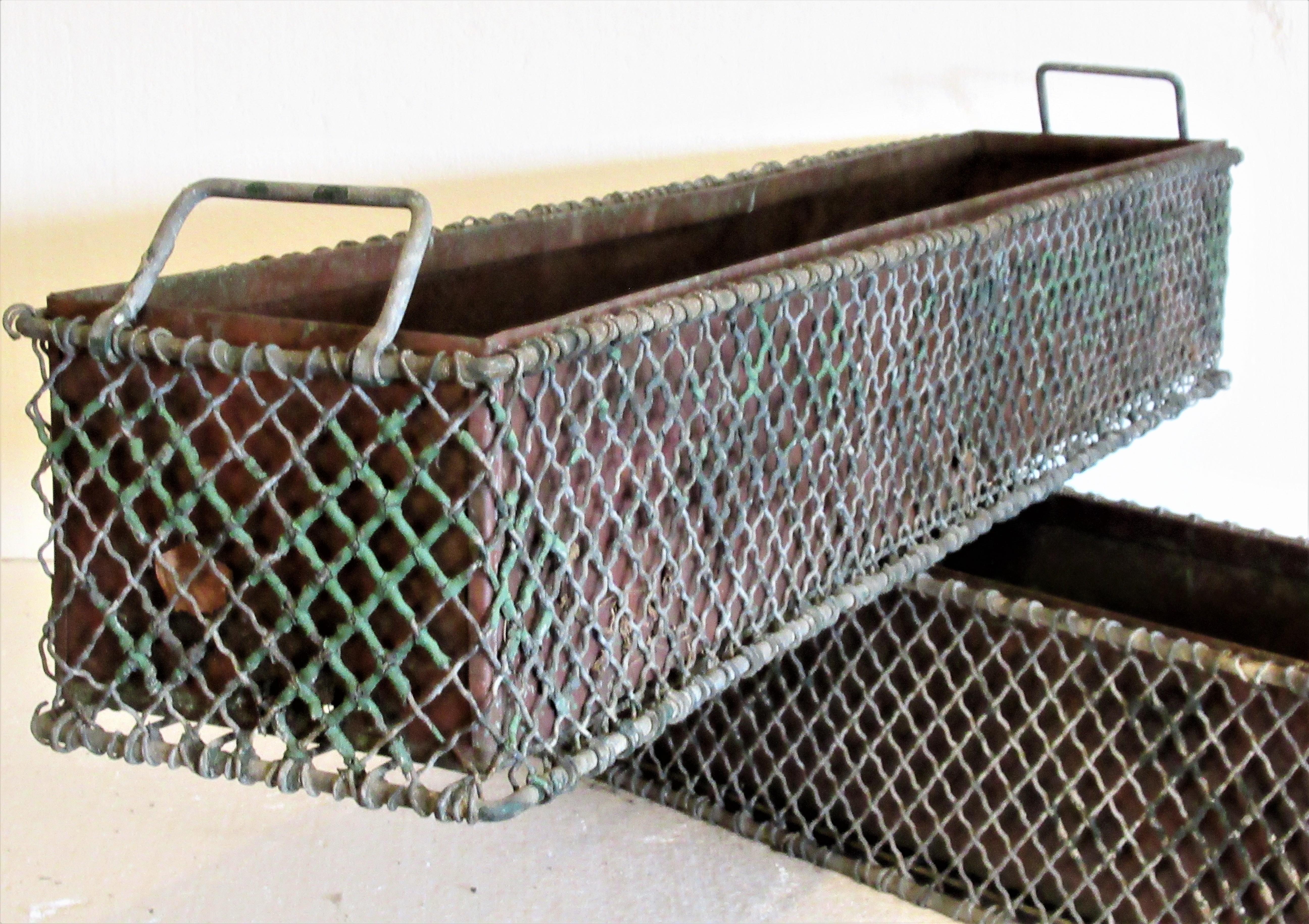 Antique French large rectangular wire window box garden planters with swing handles at each end and original copper metal inserts with drainage holes. Both planters in overall naturally aged weathered oxidized verdigris surface and areas of old worn