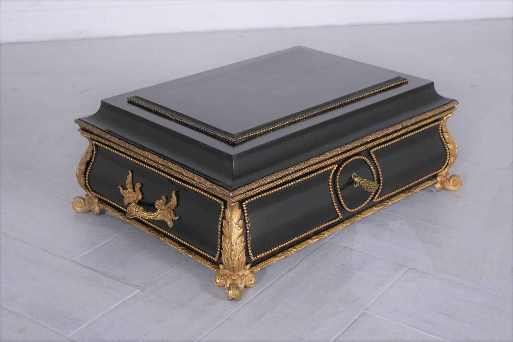 This antique french Louis XVI-style jewelry box is handcrafted out of wood and has been restored by our team of expert craftsmen. The box has a hand-carved top and is finished in its original black ebonized finish with bronze molded accents