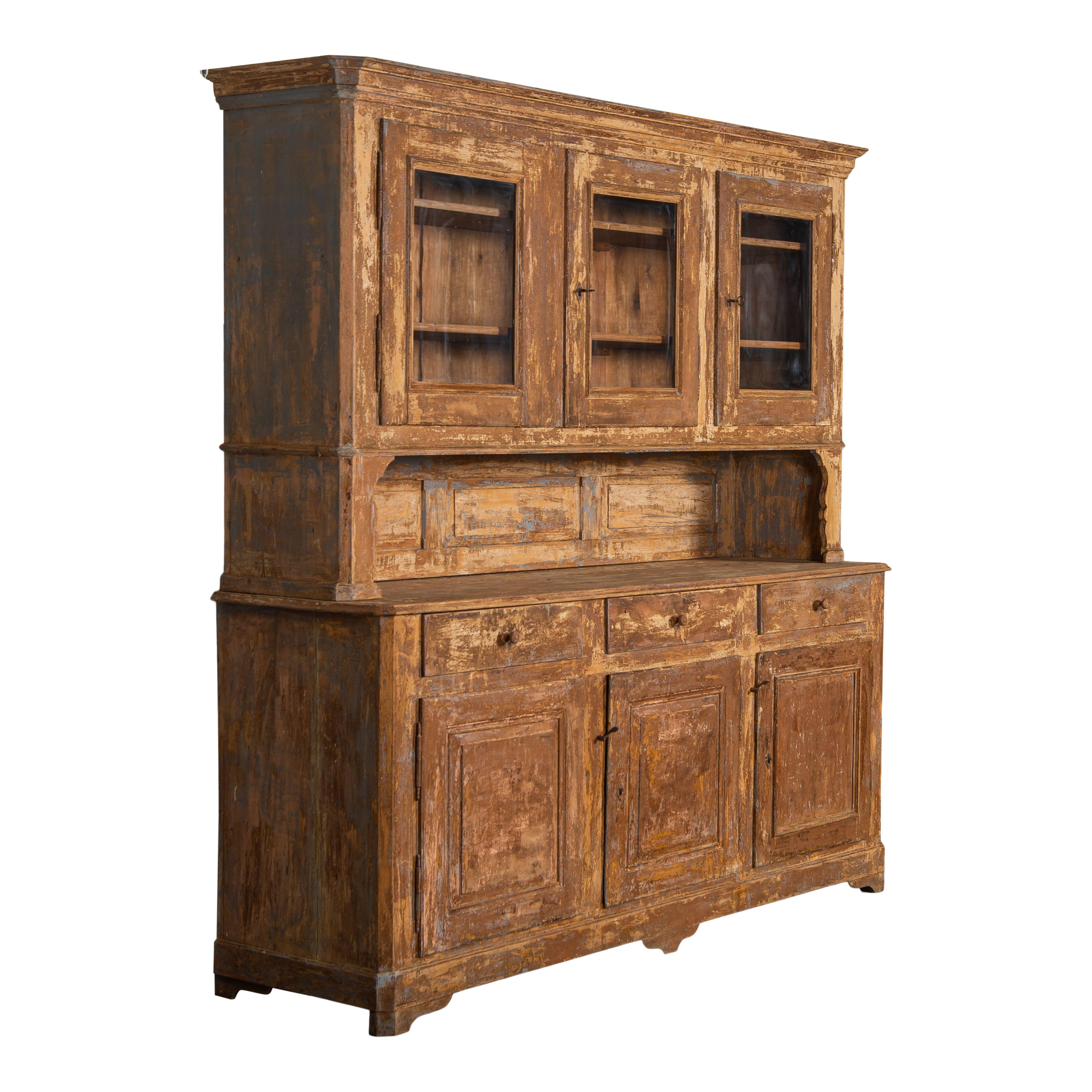 The perfect two-piece vintage wood cabinet from France. This cabinet is simple yet elegant and is sure to draw attention in any space. The chipped paint and carved details give it an amazing patina and vintage charm. The top has three cabinets with