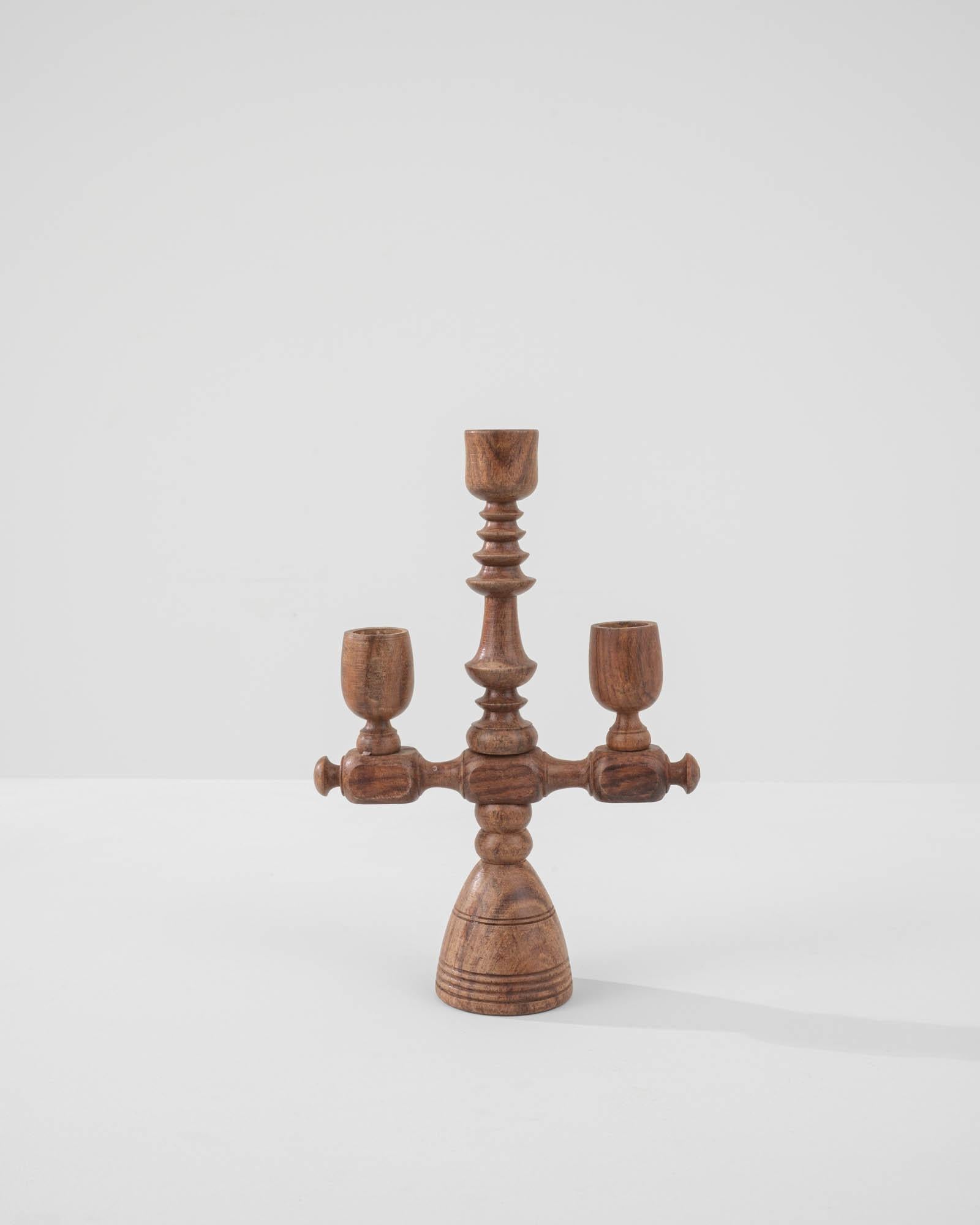 A wooden candlestick made in France in a chalet style. This elegant and capriciously crafted Chalice-like candle stick lets you add warmth whenever you would like to light a special occasion. Made of polished hardwood, this antique candlestick