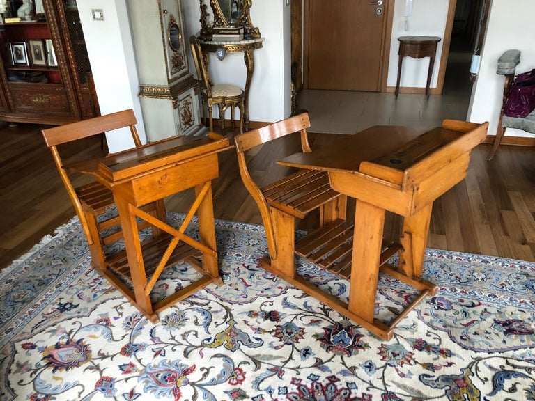 Two French vintage writing desks or school tables with seats, all attached together, made of oakwood.
Adjustable foot part all in very good condition. Very stable and comfortable. The top of the table opens and reveals a hidden drawer. Perfect