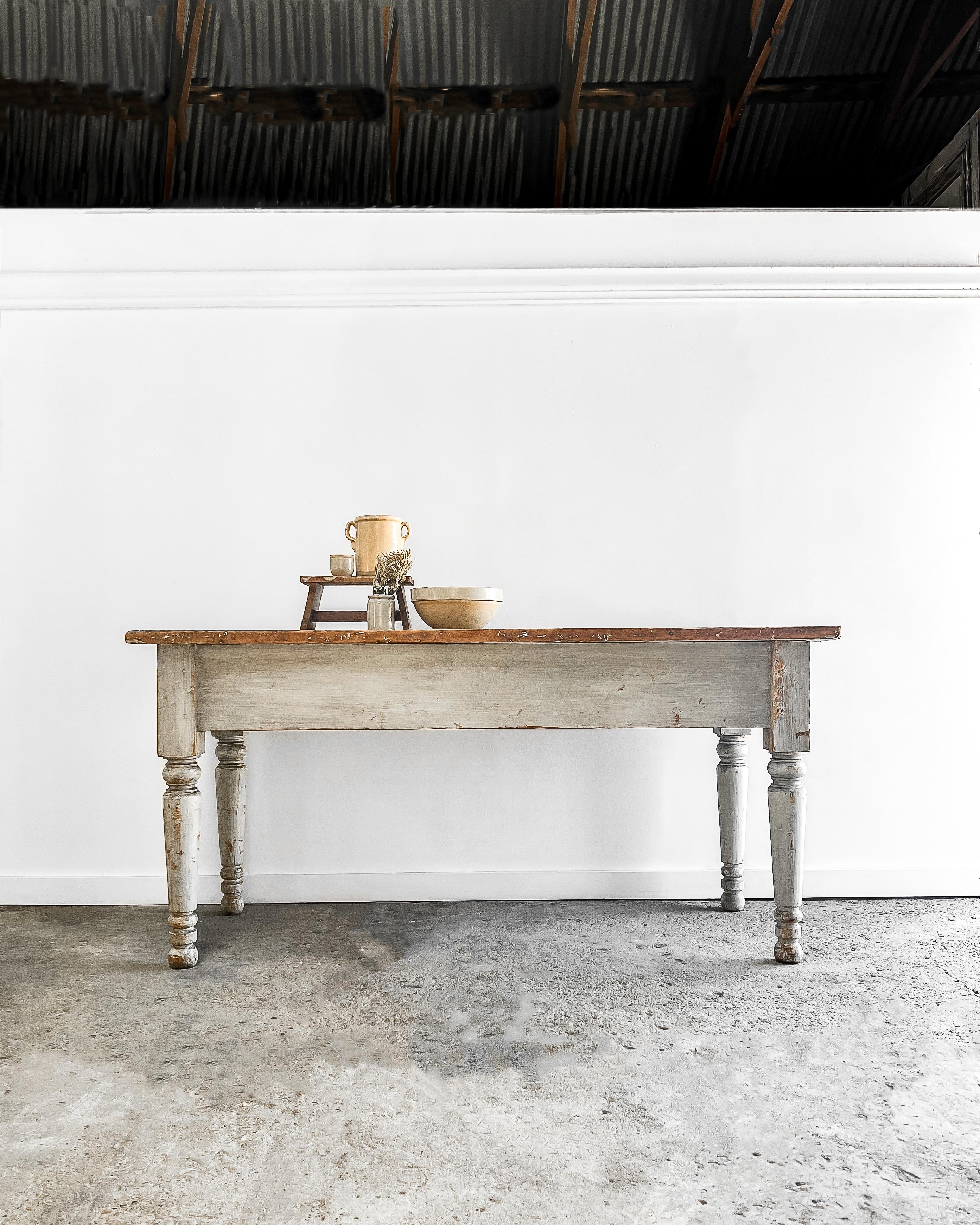 Enhance your kitchen’s style and functionality by utilizing this old French work table as an eye-catching island or prep table. Offering a generous workspace, the table boasts a scrubbed pine two-board top and painted base with the original pale