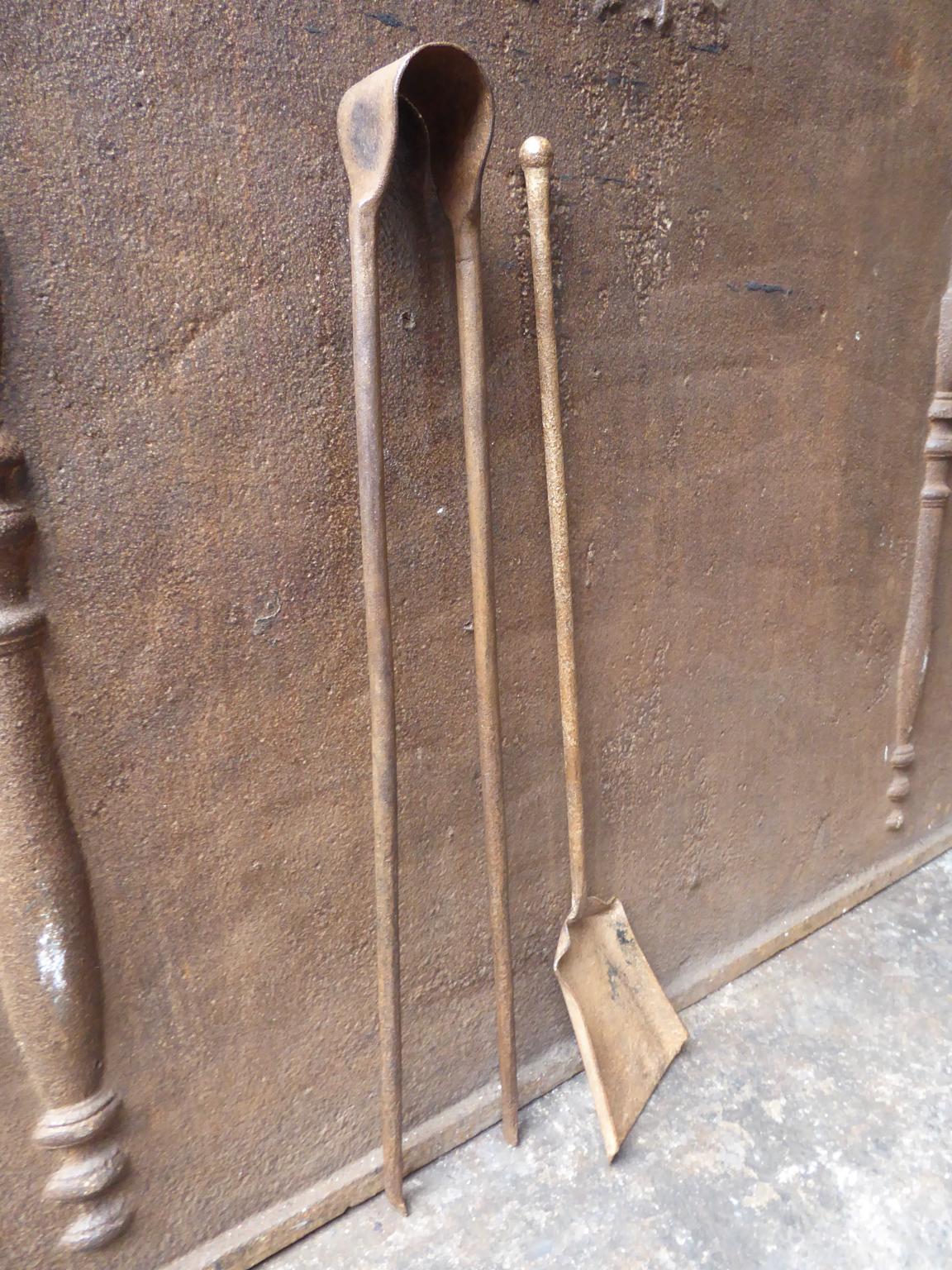 18th century French Louis XV fireplace tool set consisting of fireplace tongs and a shovel. The fire irons are made of wrought iron. They are in a good condition and are fully functional.