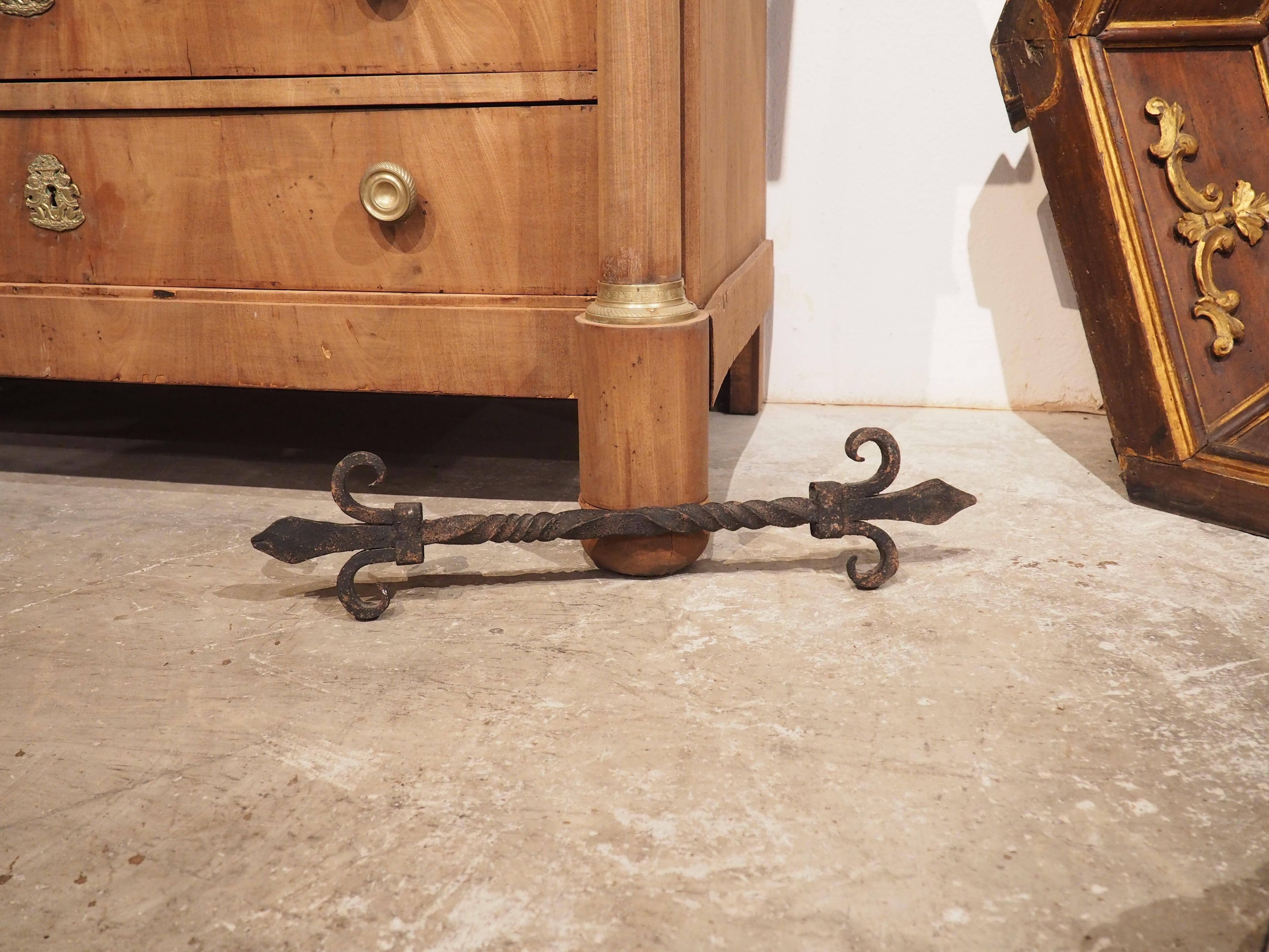 Highlighted by a turned shaft and a pair of fleur de lys terminals, this antique wrought iron architectural was hand-forged in France during the 1800’s. The fleur de lys are attached to the end of the center element by a rectangular brace, which was