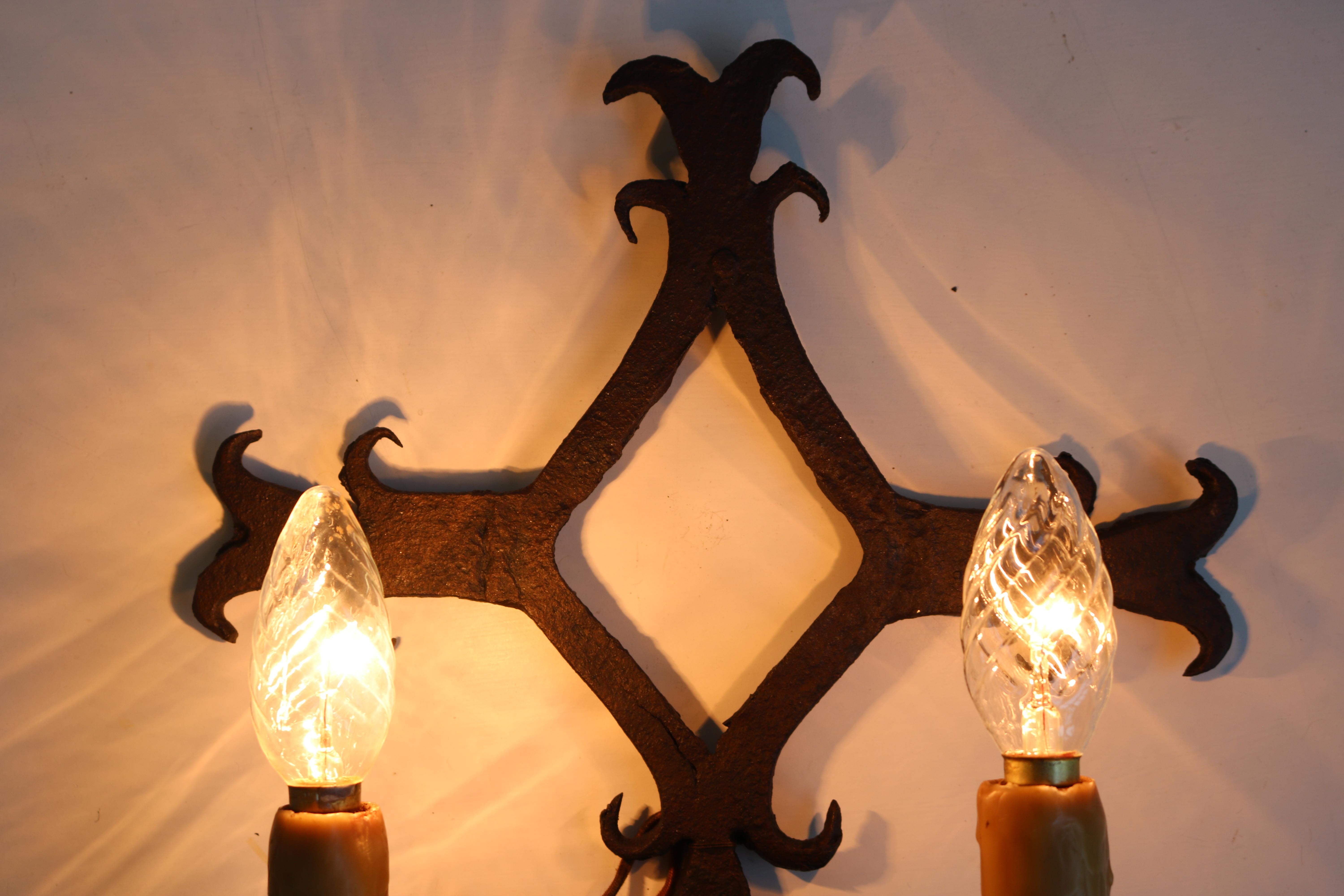 Lovely pair of hand-crafted wrought iron wall lights from France 1900. Spanish style or Arts & Crafts. 
They are heavy and fully hand made, really gorgeous details. 
Fully original with gorgeous candle wax covered light sockets. 

They are in