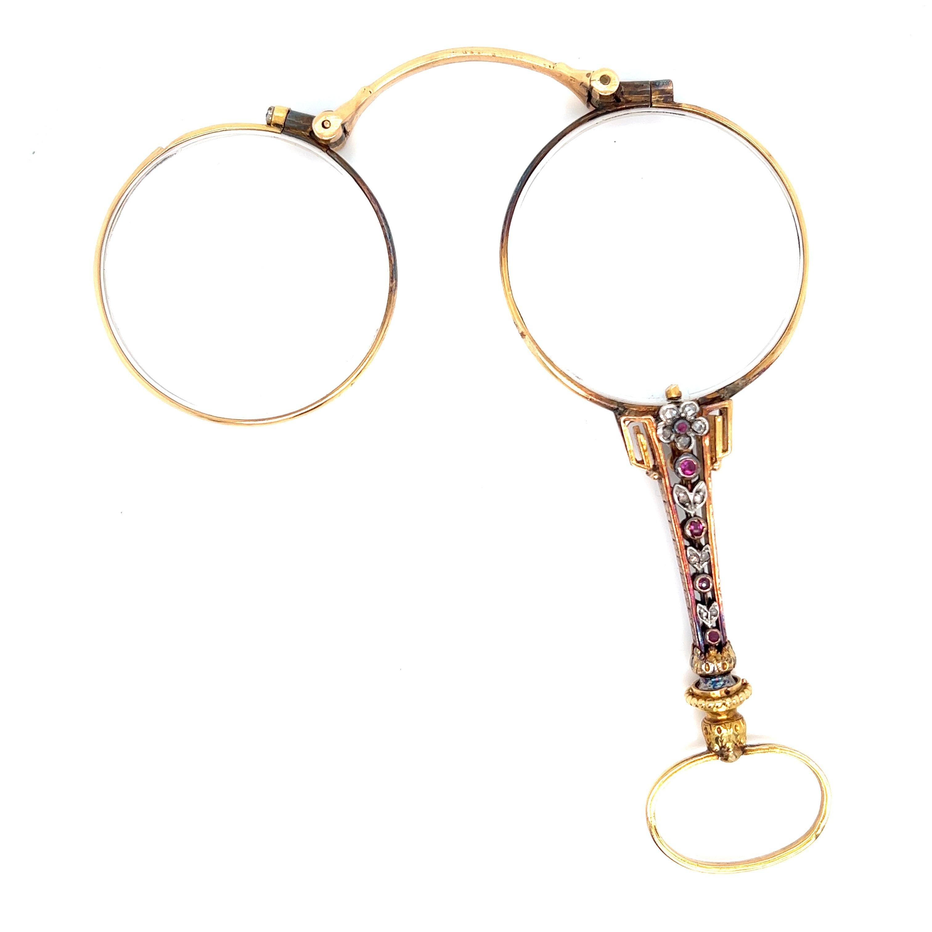 Antique French yellow gold lorgnette with folding round lenses

Handle is set with white gold flowerhead and leaves, eleven rose-cut diamonds and five bezel-set round rubies on each side 

Size: length 4 inches; glasses: width 1.5 inches
Total
