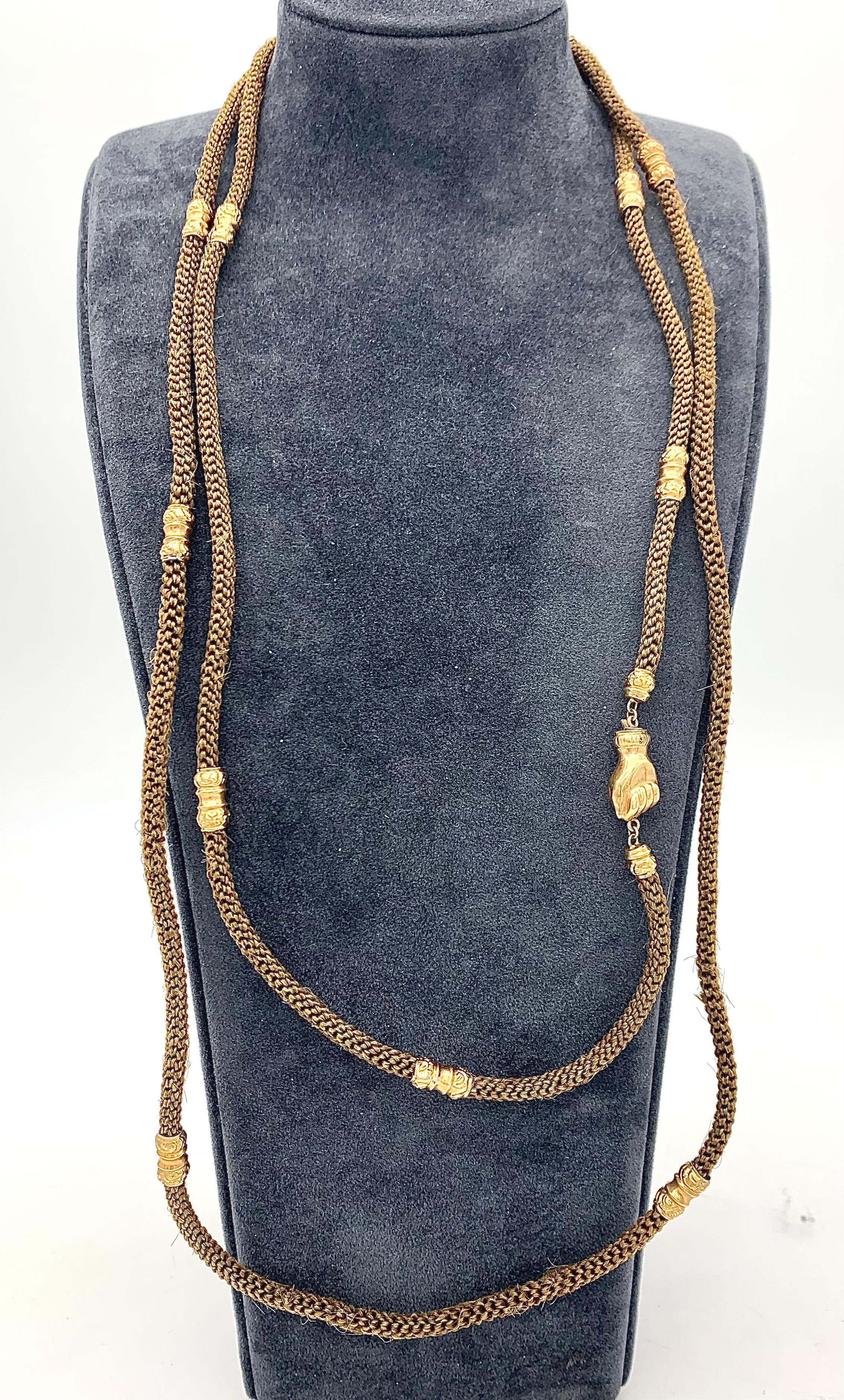 This beautiful hair chain was created in 1825 ca. It is made out of handwoven brown hair and 14 karat gold. The chain was intended as a token of friendship and sentiment. The hair alternates with twelve finely embossed gold elements. Both ends of