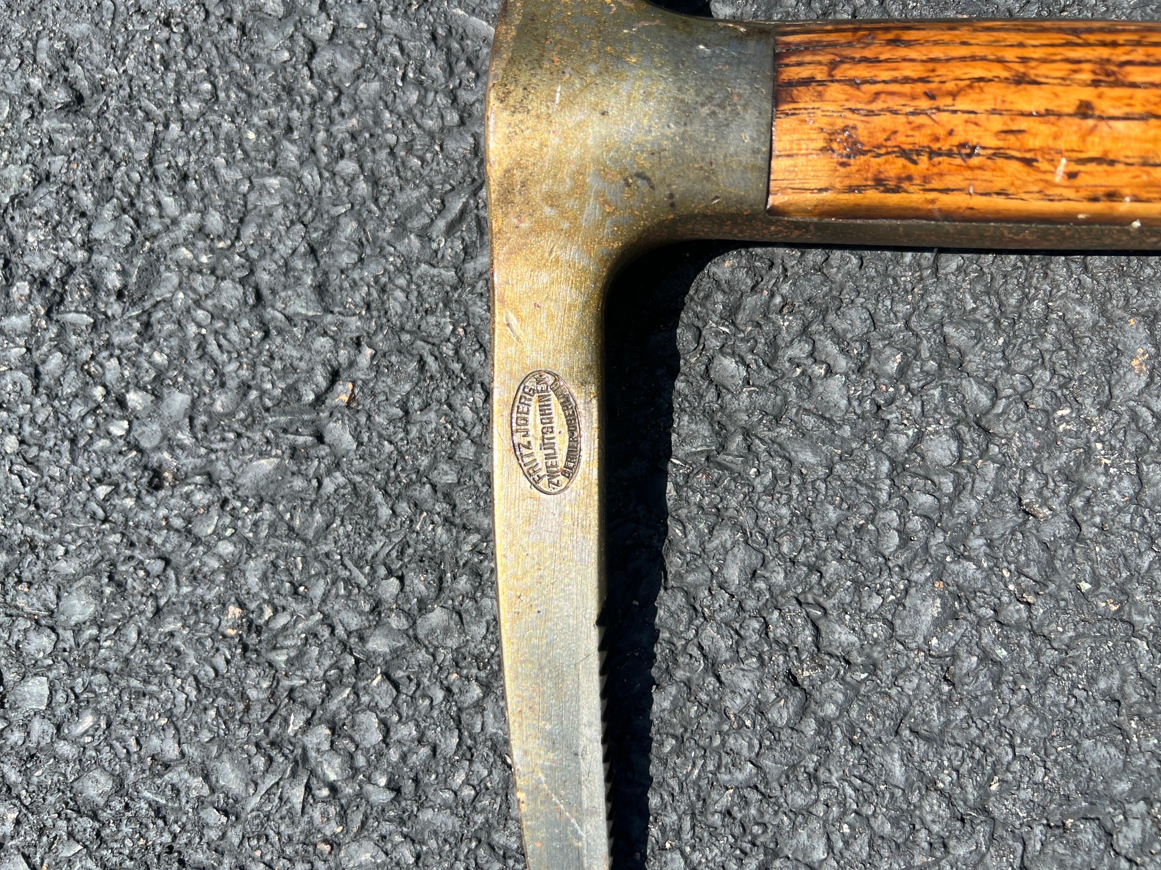 A great ice axe that was made by the renown blacksmith Fritz Jörg in the small area of Zweilütschinen in the Interlaken-Oberhasli district. 
One side of the head is inscribed with “F. JORG ZWEILUTSCHINEN BERNER OBERLAND”. 
It has a wonderful patina