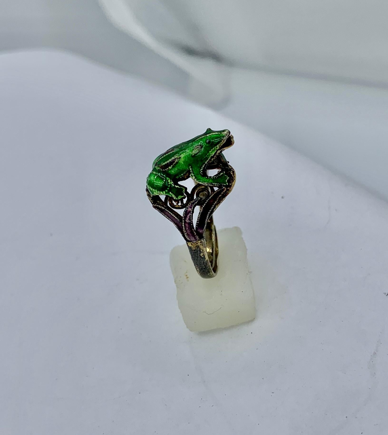 This is an absolutely wonderful antique Frog Ring in Silver with gorgeous green enamel and with the frog's tongue curving up to catch its favorite snack!   The stunning fully modeled three dimensional frog is depicted perched on green leaves with