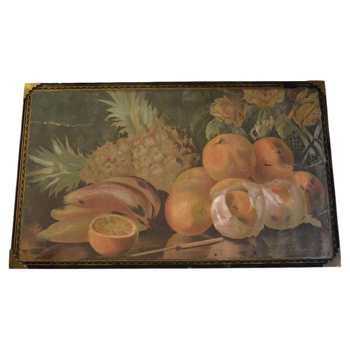 A beautiful antique still life print of fruit displayed on a table. This unique piece is created from wood, and features a paper print under glass. The print includes fruits of various types such as pineapple, banana, oranges next to a vase of