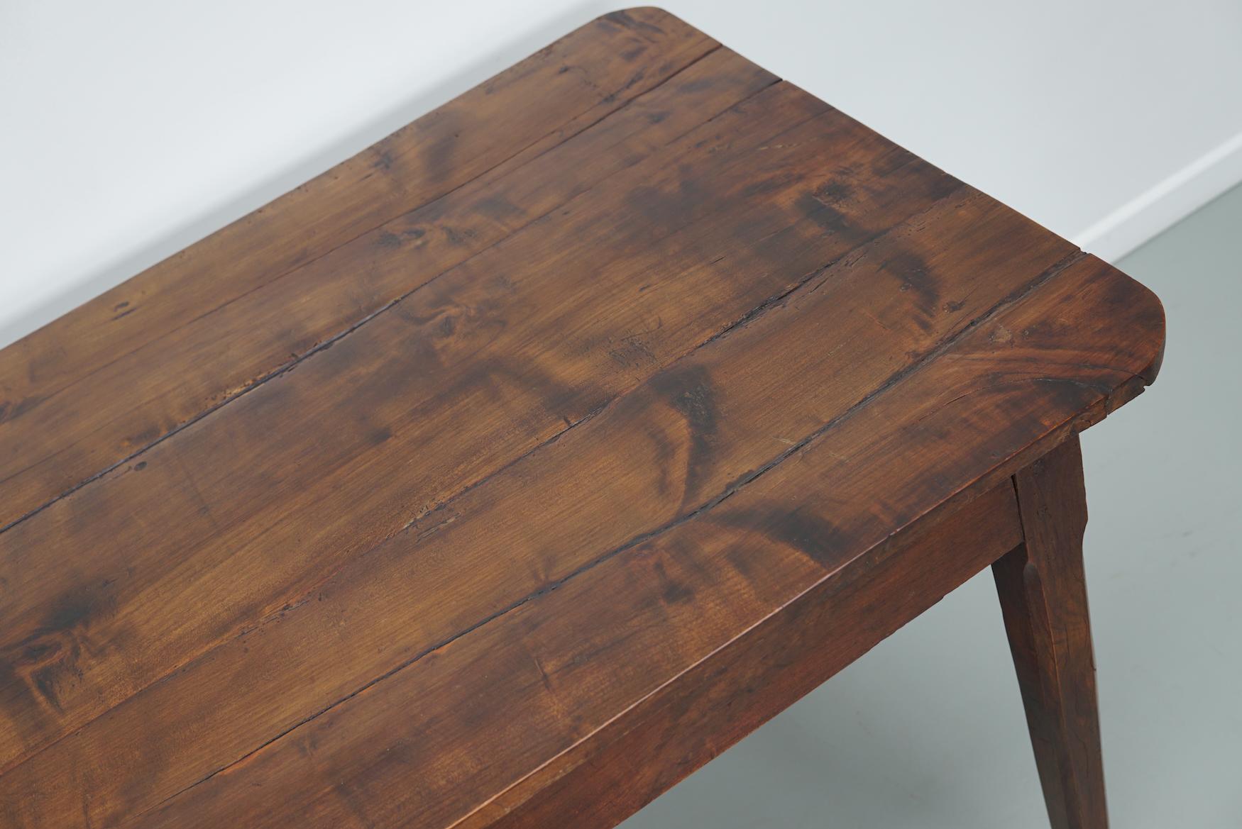 Questo elegante tavolo è stato realizzato in Francia nel XIX secolo. Il tavolo è stato realizzato in legno massiccio di frutta con bellissime venature. Ha un colore molto caldo e il tavolo presenta segni d'uso, vecchie riparazioni e un'ottima