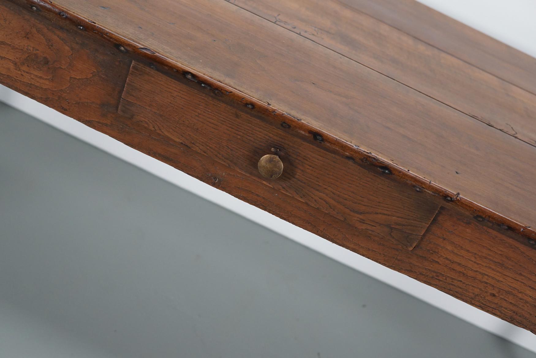 Questo elegante tavolo è stato realizzato in Francia nel XIX secolo. Il tavolo è stato realizzato in legno di frutta e quercia/castagno con bellissime venature. Ha un colore molto caldo e il tavolo presenta segni d'uso, vecchie riparazioni e