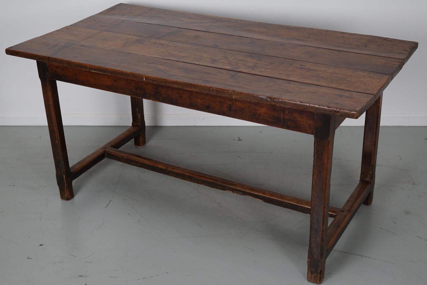 This elegant table was made in France in the 19th century. The table was made in solid fruitwood with beautiful grain patterns. It has a very warm color and the table shows marks of use, old repairs and a has a great patina. The knee height is 61 cm.