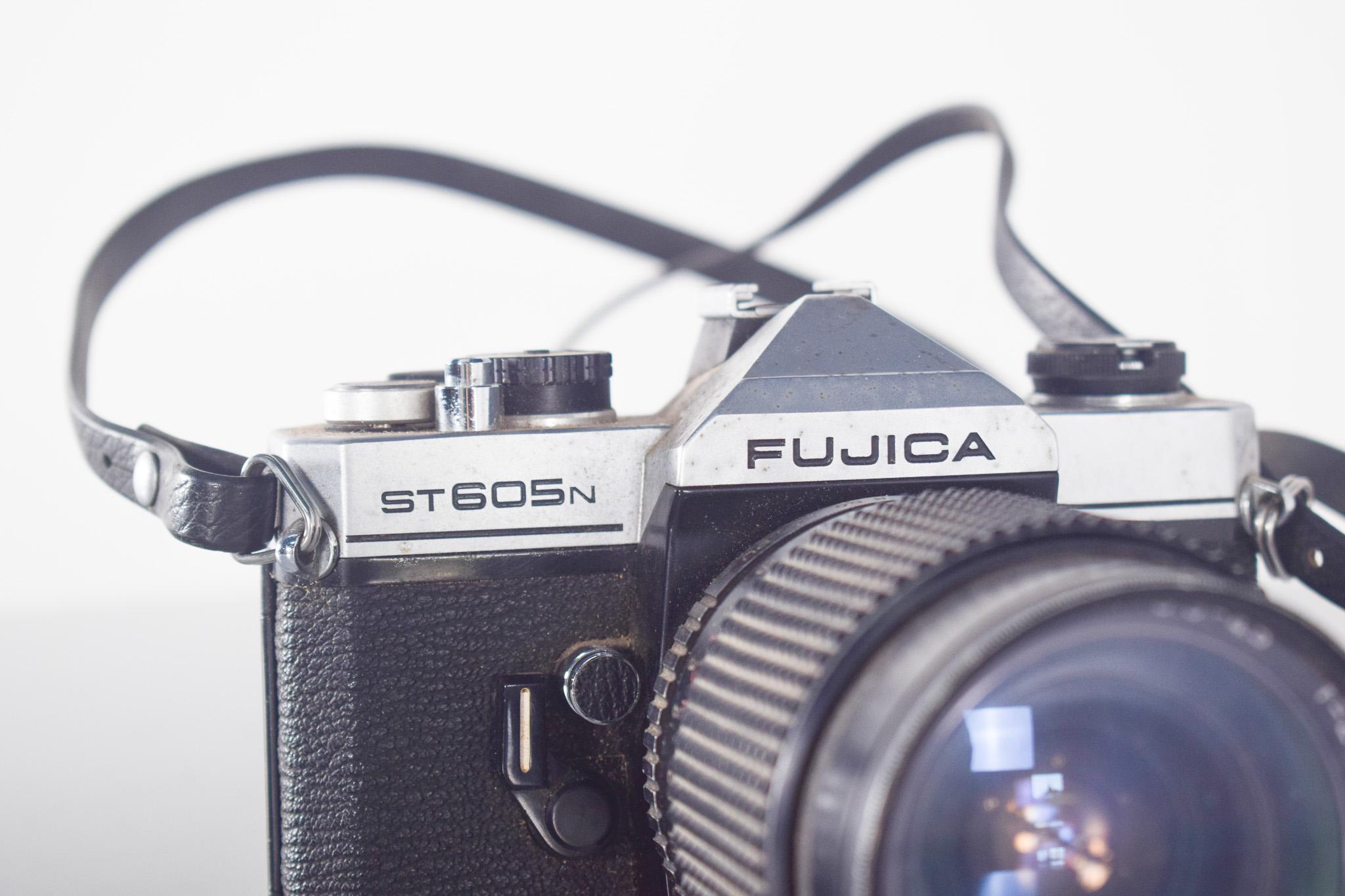 Appareil photo Fujica ST605N. Un modèle classique de reflex 35 mm produit par Fuji à la fin des années 1970. Avec son boîtier métallique robuste et ses détails noirs texturés, cet appareil photo reflète l'esthétique fonctionnelle et durable de