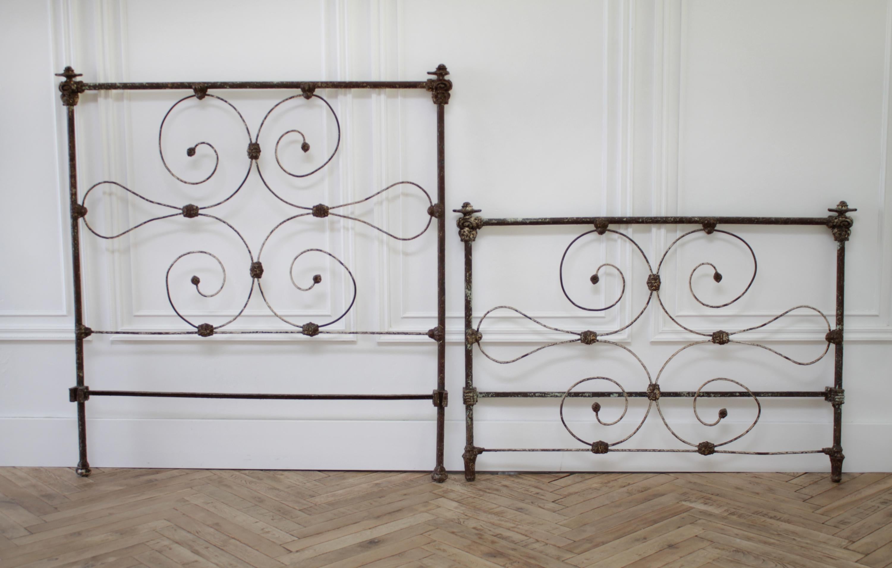 Beautiful antique iron bed, with original rails. The patina and paint have a wonderfully worn, weathered look. Fits US size full size mattress. Large finials at each post, one has a smaller lip. Large scrolled iron headboard and footboard. This bed