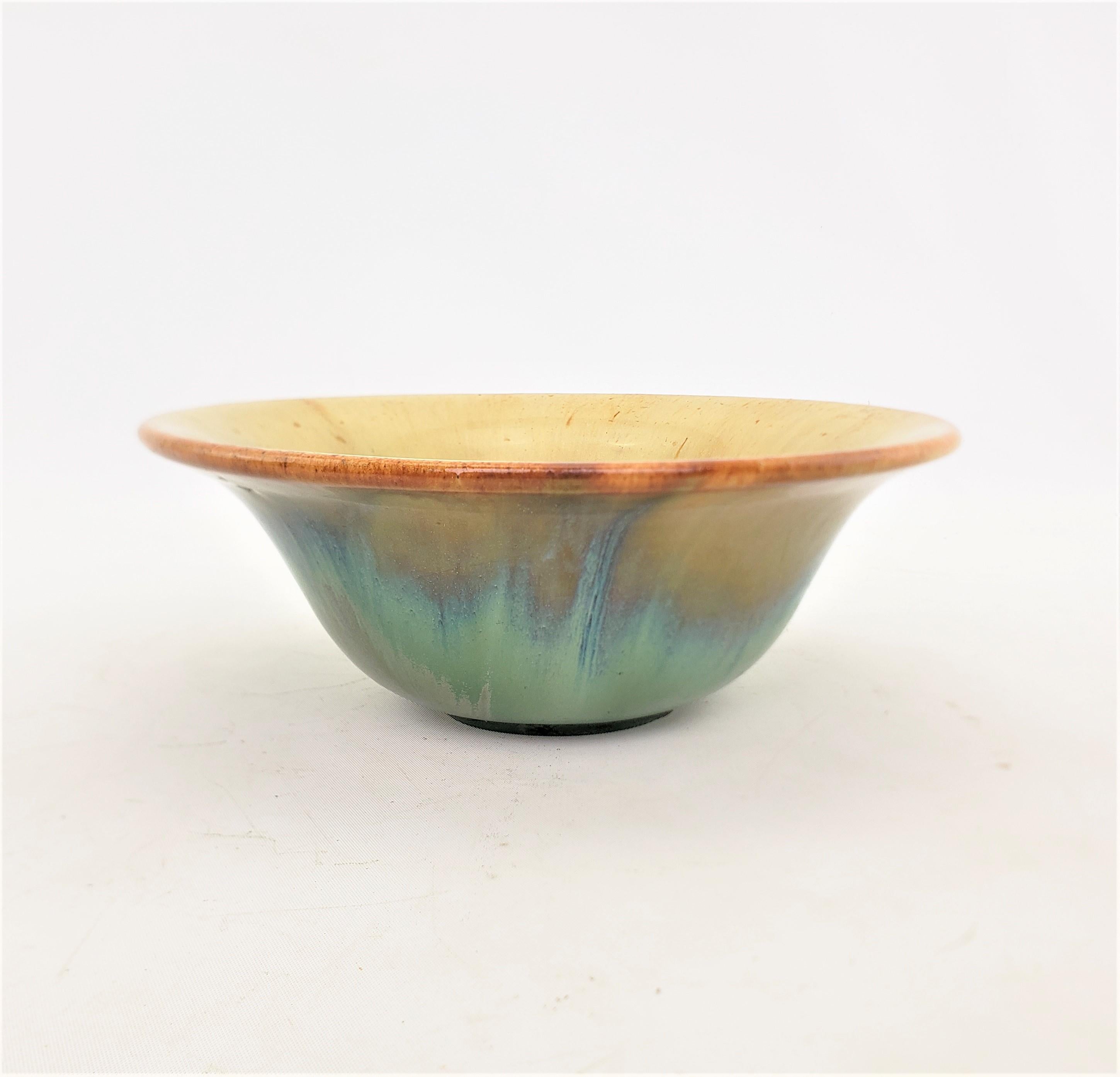 This antique art pottery bowl was made by the well known Fulper Pottery Company of the United States in approximately 1920 in their signature Arts and Crafts style. The bowl is composed of pottery with a slightly turned rim with a brown accent and