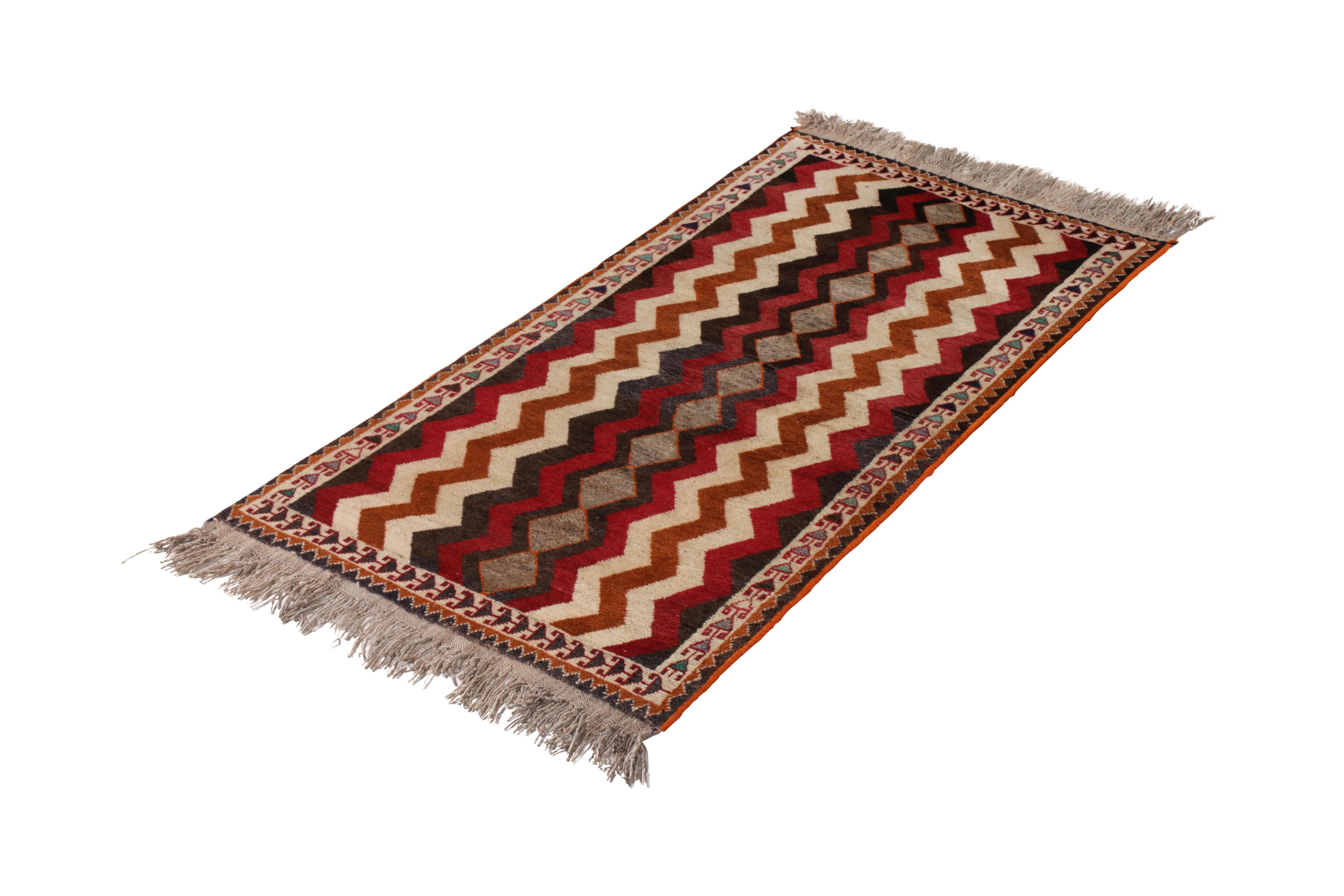 Made with hand knotted wool originating circa 1910-1920, this antique Persian runner celebrates a classic Gabbeh rug chevron pattern venerated in this distinguished family of Oriental rugs of tribal sensibility. The mirroring of the pattern along a