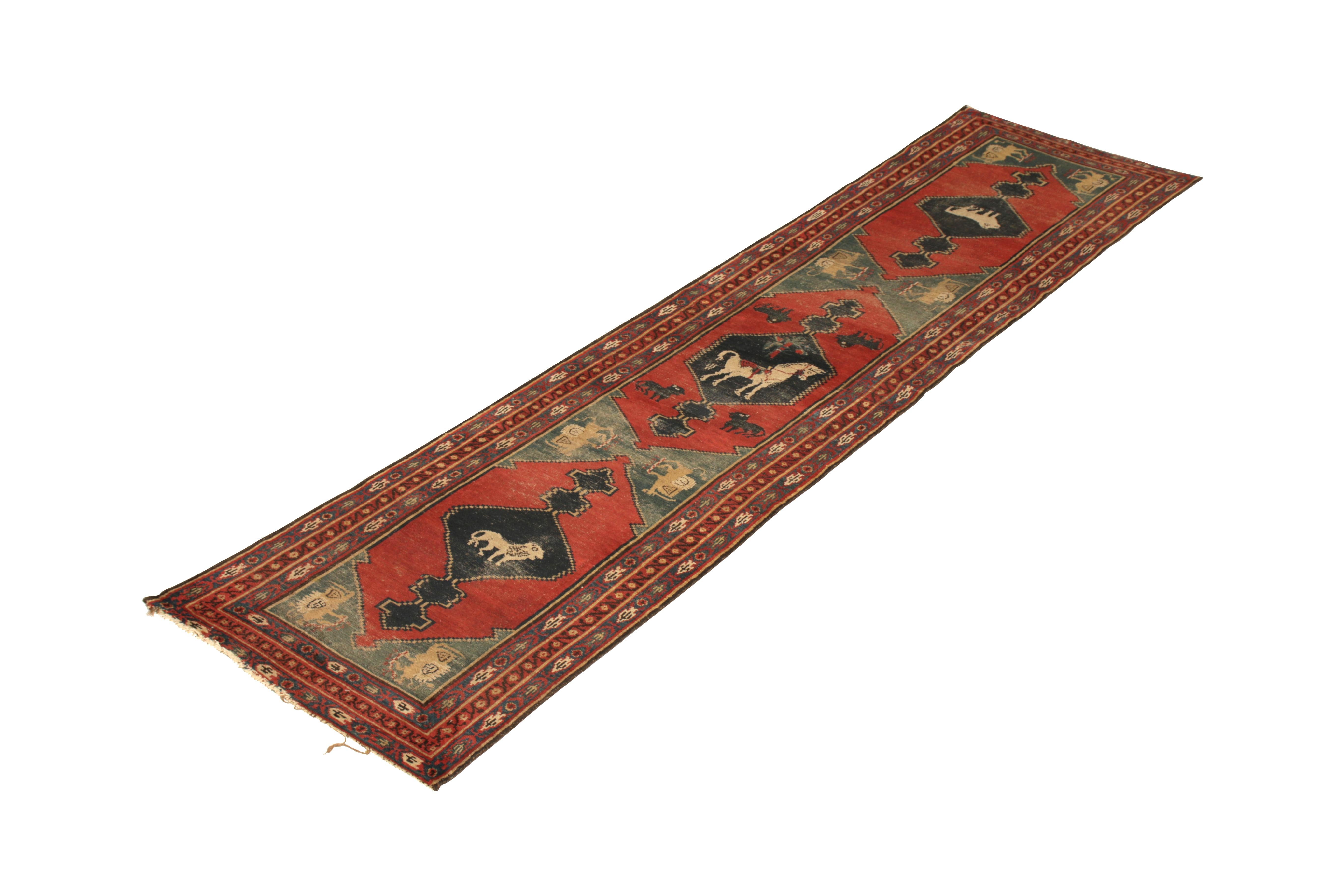 Handmade with hand knotted wool originating circa 1910-1920, this collectible Gabbeh wool rug is an antique Persian runner in red, blue, and beige colorway hues. This particular transitional antique Persian rug features a rare pictorial reflecting