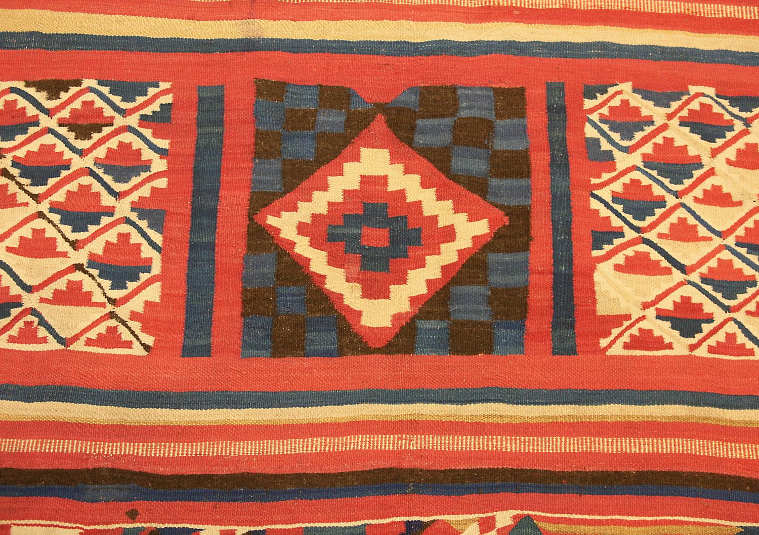 This is an antique Gafsa Tunisian kilim woven during the end of the 19th century circa 1900 and measures 220 x 185 cm in size. This textile is designed with rows of polychrome geometric motifs including arrows, abstract camels and, medallions all