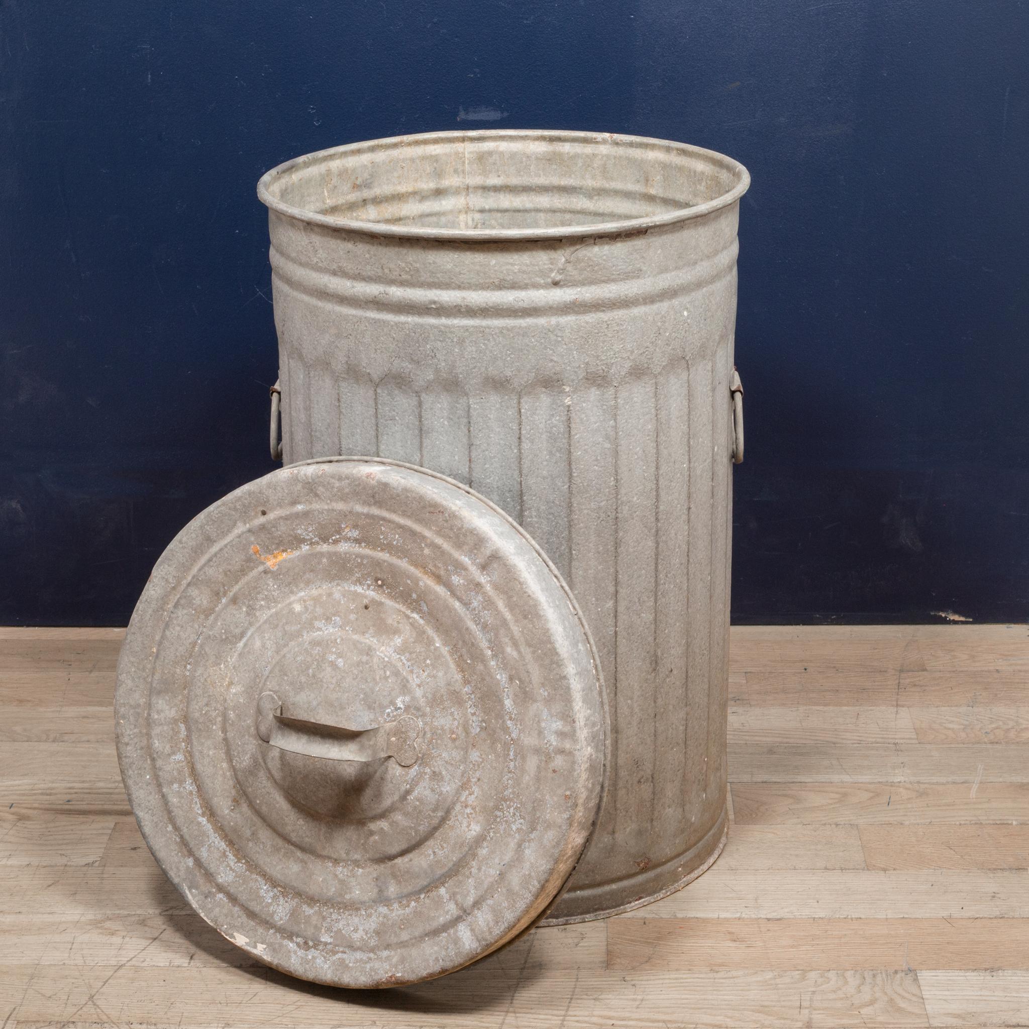 About

All original early 20th century antique American vintage industrial outdoor trash can with original handled lid. The robust waste can is comprised of heavy gauge galvanized steel. It retains the original opposed bent steel drop handles