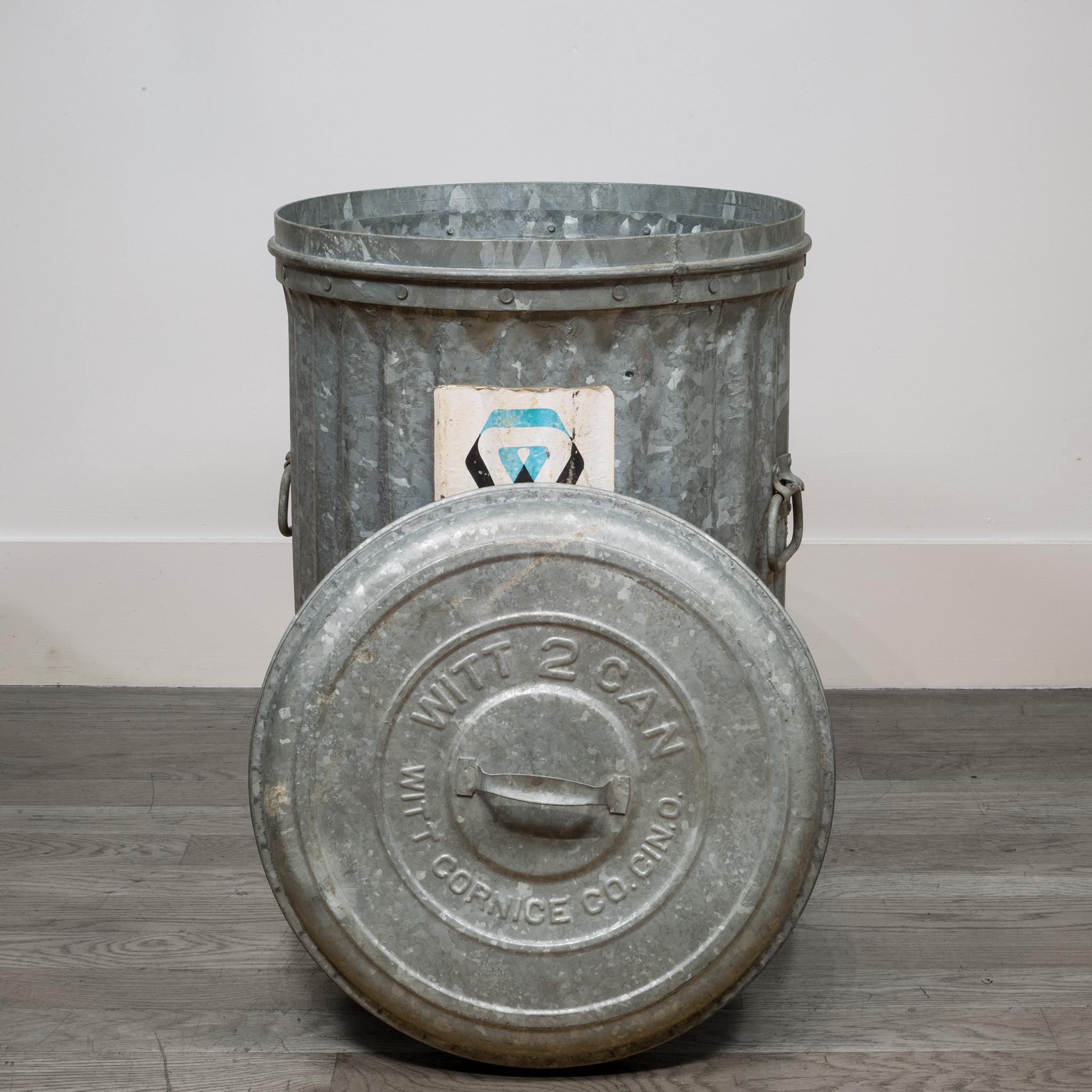 About

All original and completely intact early 20th century antique American vintage industrial outdoor trash can with original handled lid. The robust waste can is comprised of heavy gauge galvanized steel with riveted joint reinforcement. It
