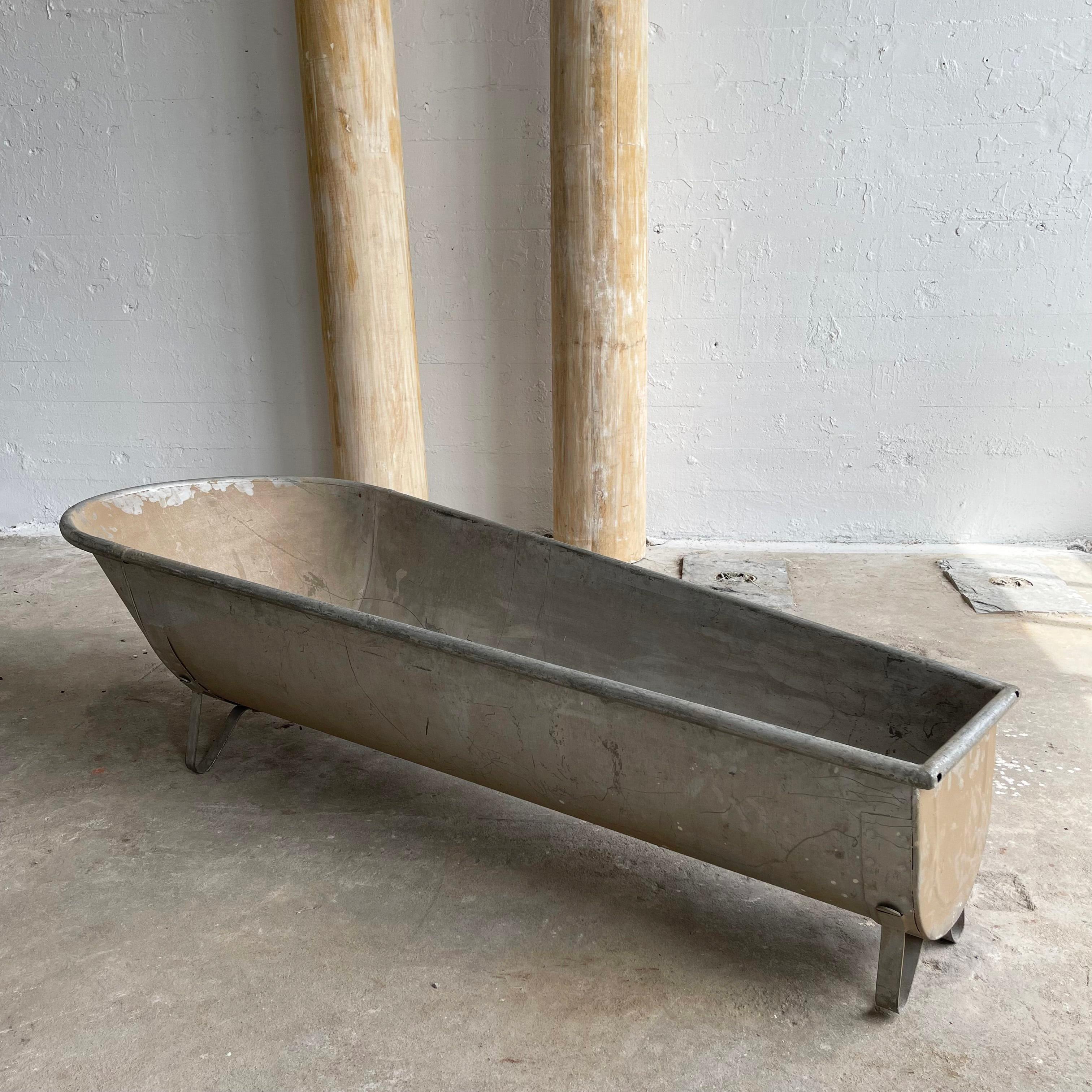 Antique, galvanized tin, cowboy wash tub circa 1890's is a gorgeous addition to any rustic, primitive or industrial decor. The full sized tub tapers from 27 inches to 14 inches and slopes from 19 inches to 15 inches height. There is a drain present