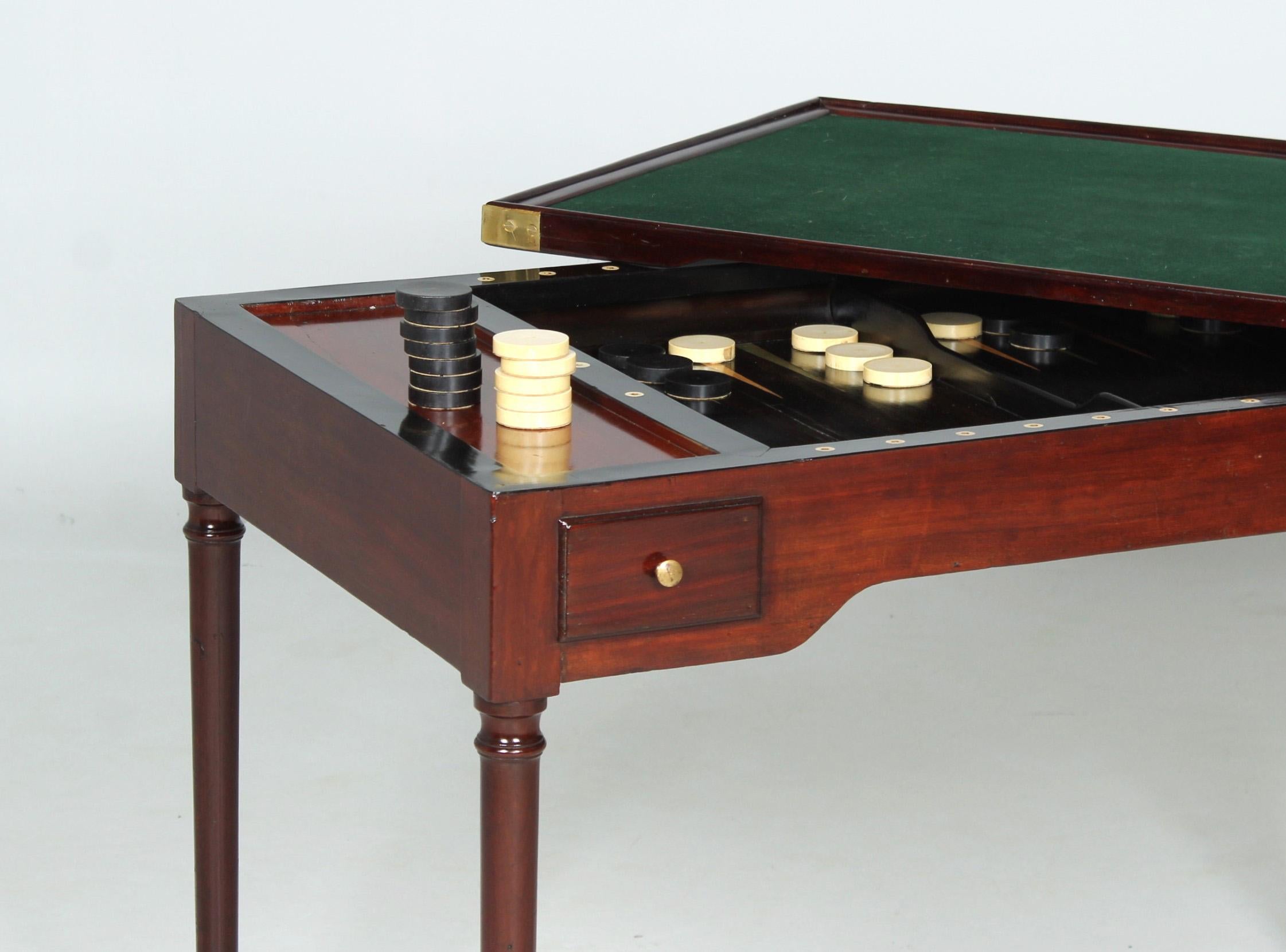 Antique Tric Trac game table

France
Mahogany
Directoire around 1800

Dimensions: H x W x D: 77 x 114 x 64 cm

Description:
Piece of furniture standing on round legs with brass surrounds.

In the frame, from both sides, there are one long drawer and