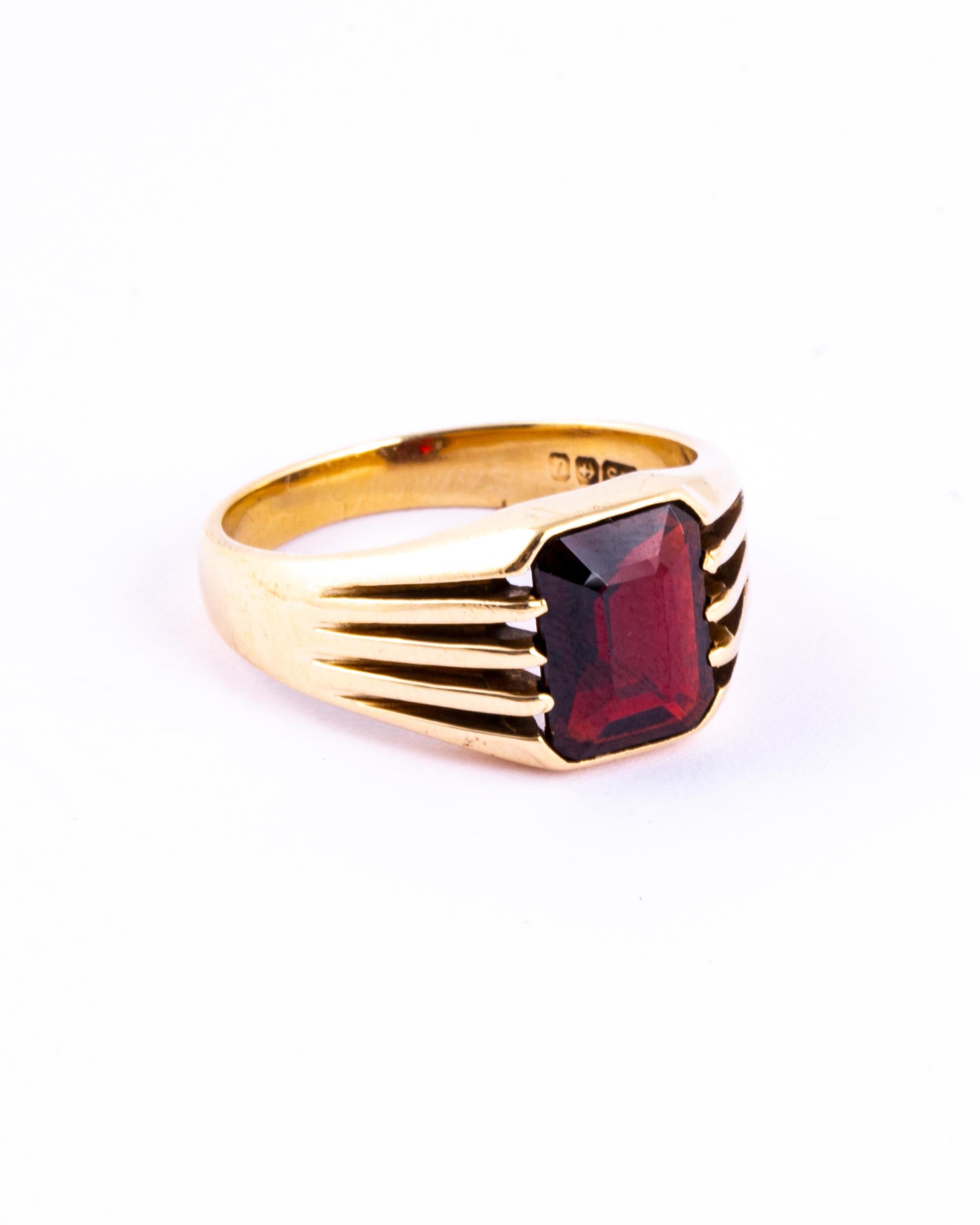 This simple style signet ring holds a garnet stone and the shoulders are made up of five strips of glossy gold. Made in Birmingham, England. 

Ring Size: P or 7 3/4
Stone Dimensions: 9x7mm

Weight: 5.5g