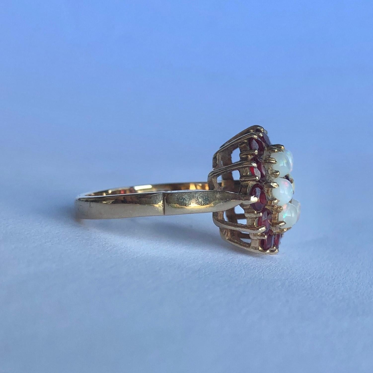 This striking ring holds round cut garnets totalling approx 1.3carat and 6 shimmering opals. All the stones sit in 9carat gold claws. Made in London, England. 

Ring Size: M 1/2 or 6 1/2 
Cluster Diameter: 15mm
Height Off Finger: 9mm

Weight: 4.8g